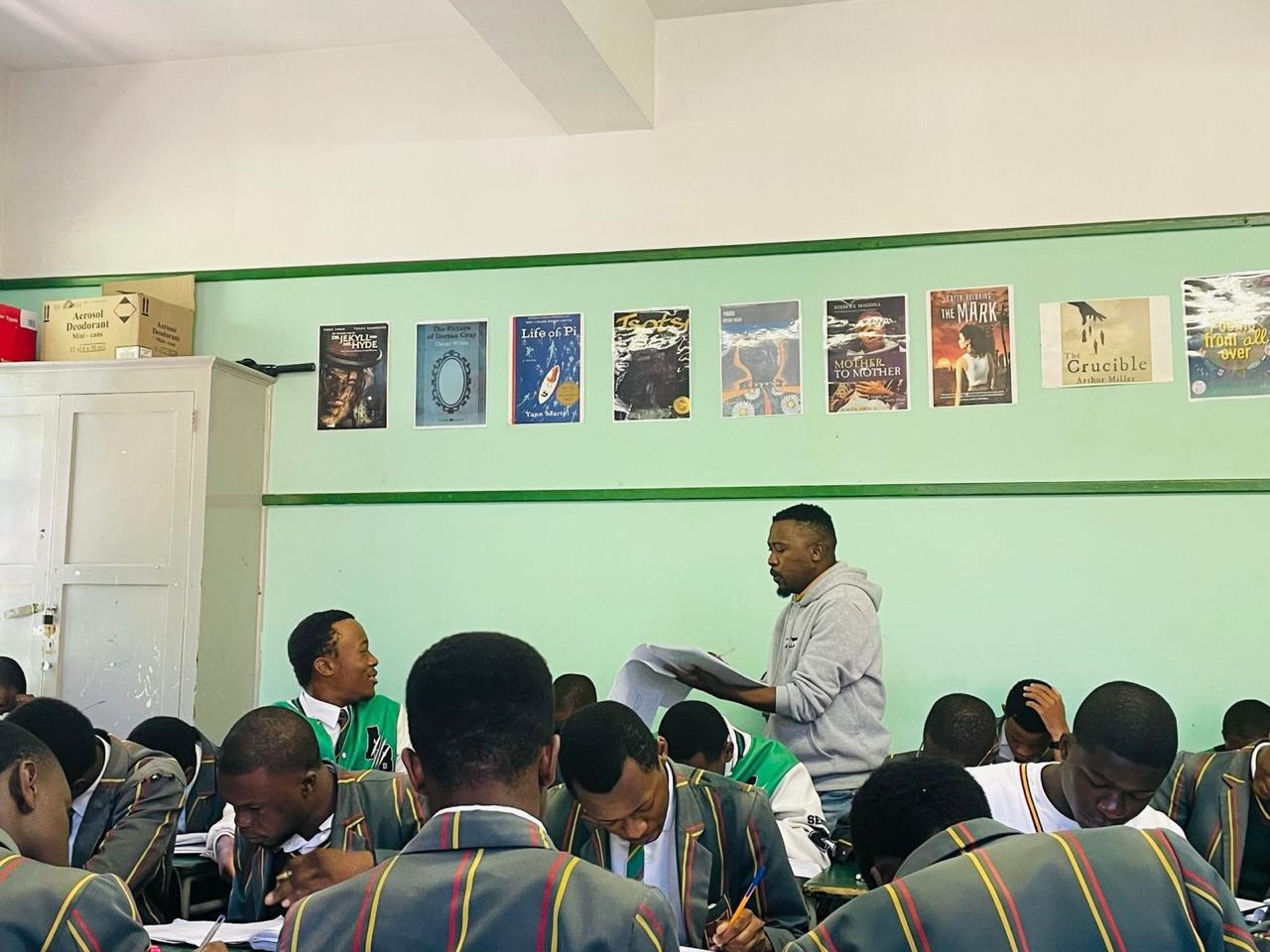 man wearing gray polo shirt beside dry-erase board