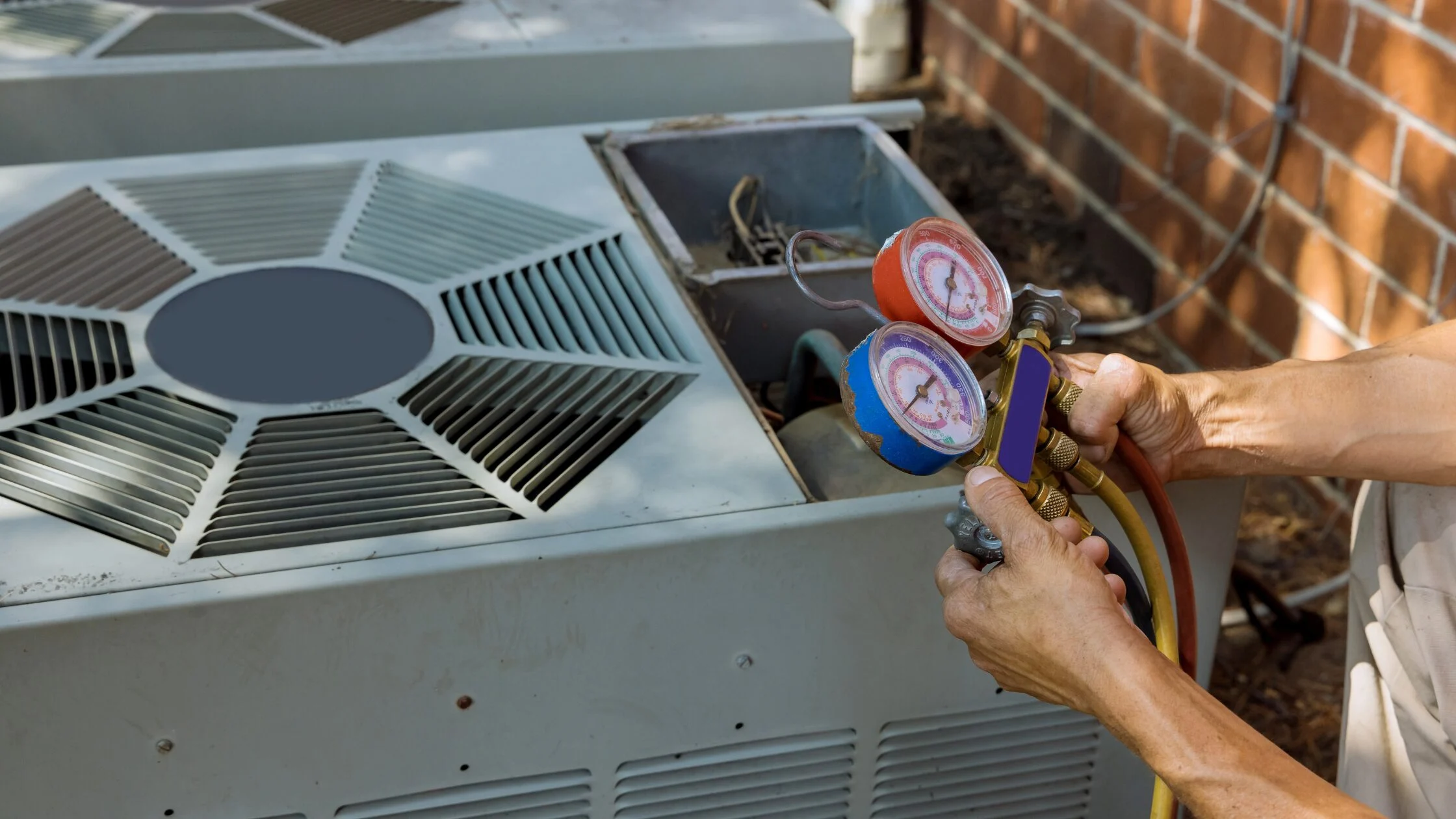 Airconditioning outdoor unit undergoing preventative maintenance by a technician