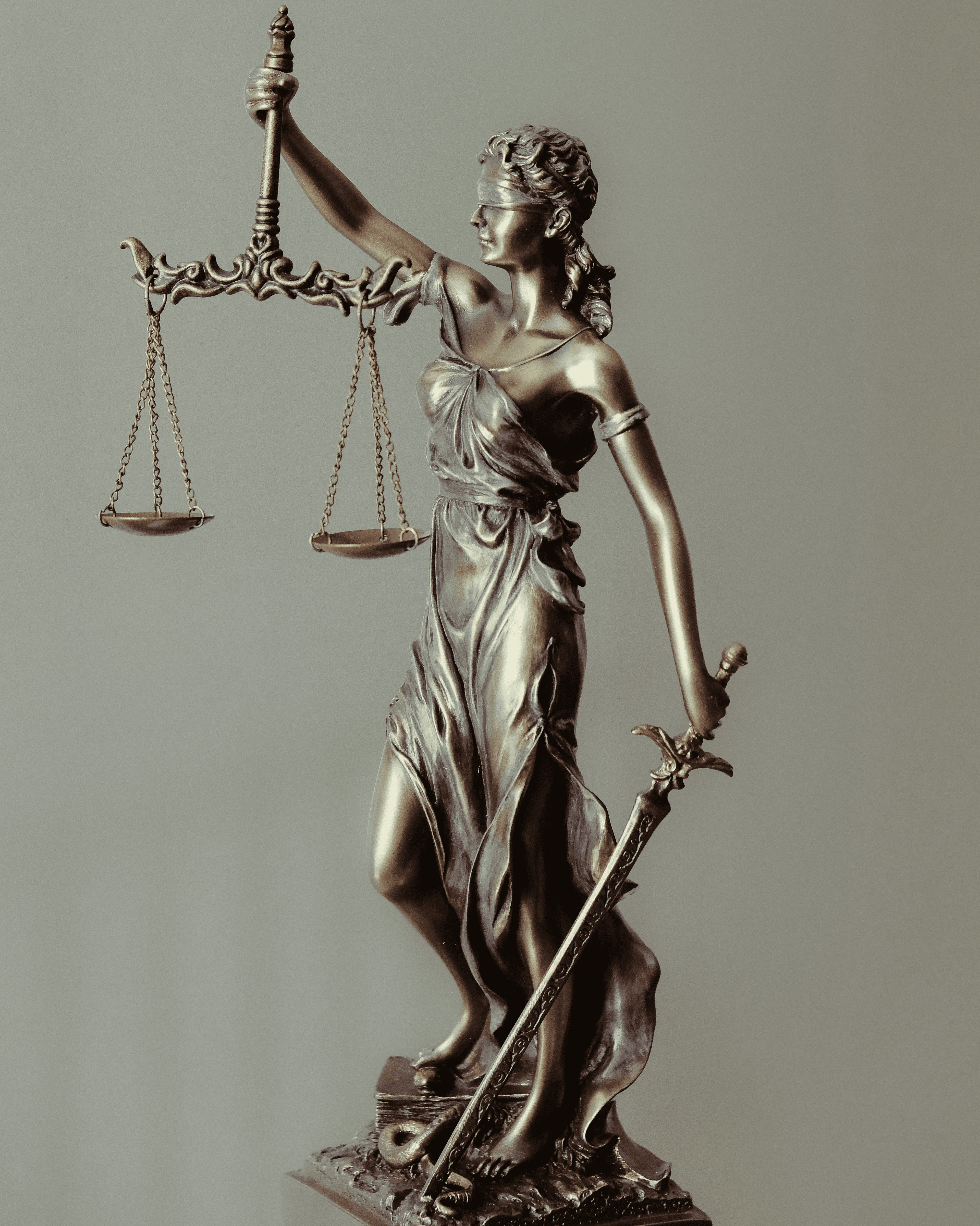 woman in gold dress holding sword figurine