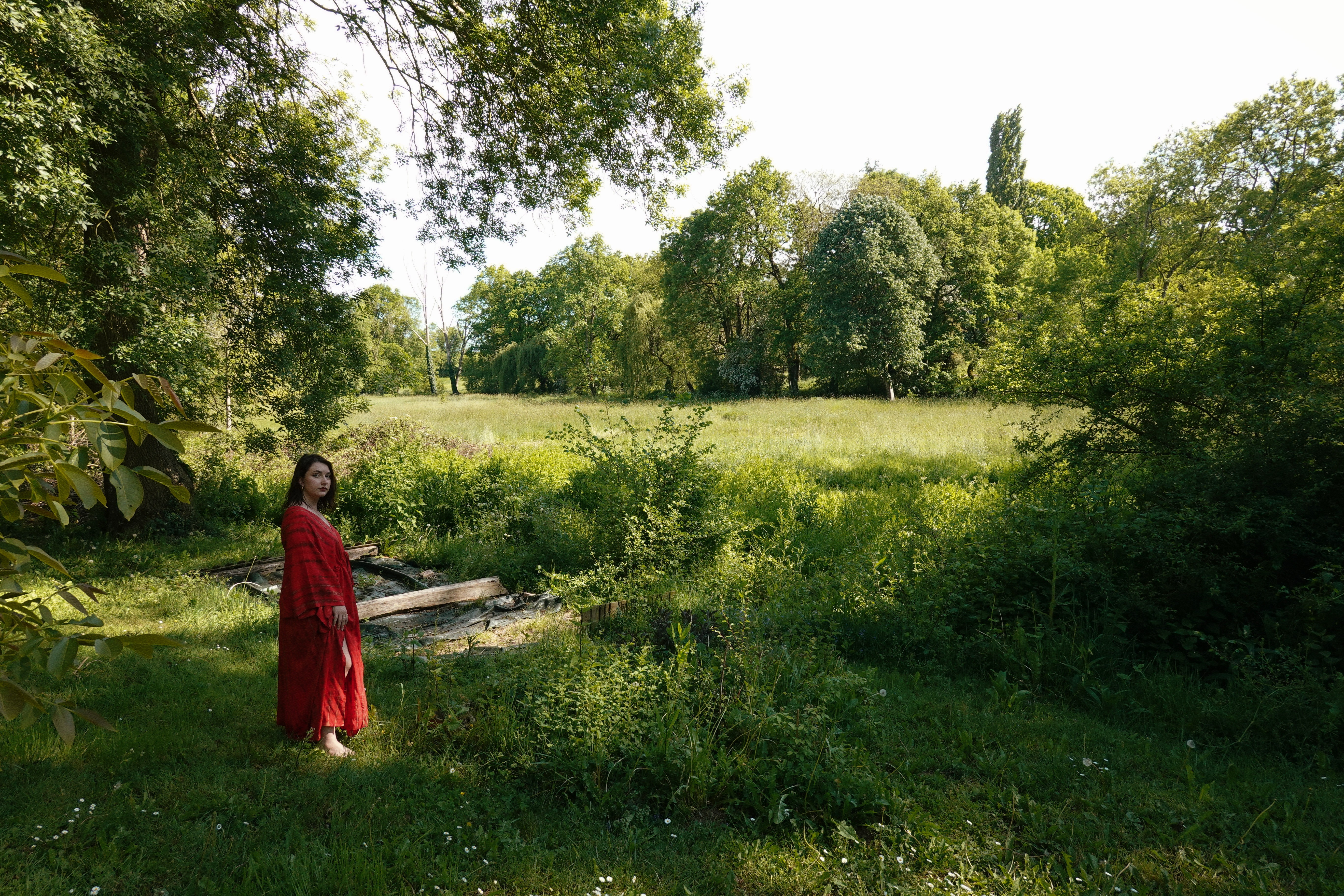 woman in brown long-sleeved top standing beside wall