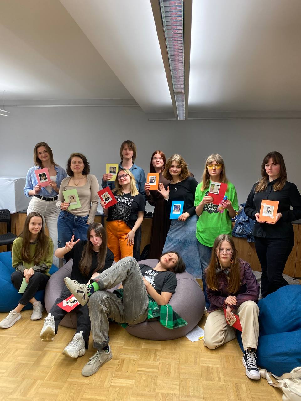 Gruppe junger Menschen, die ihre Porträts in die Kamera halten.