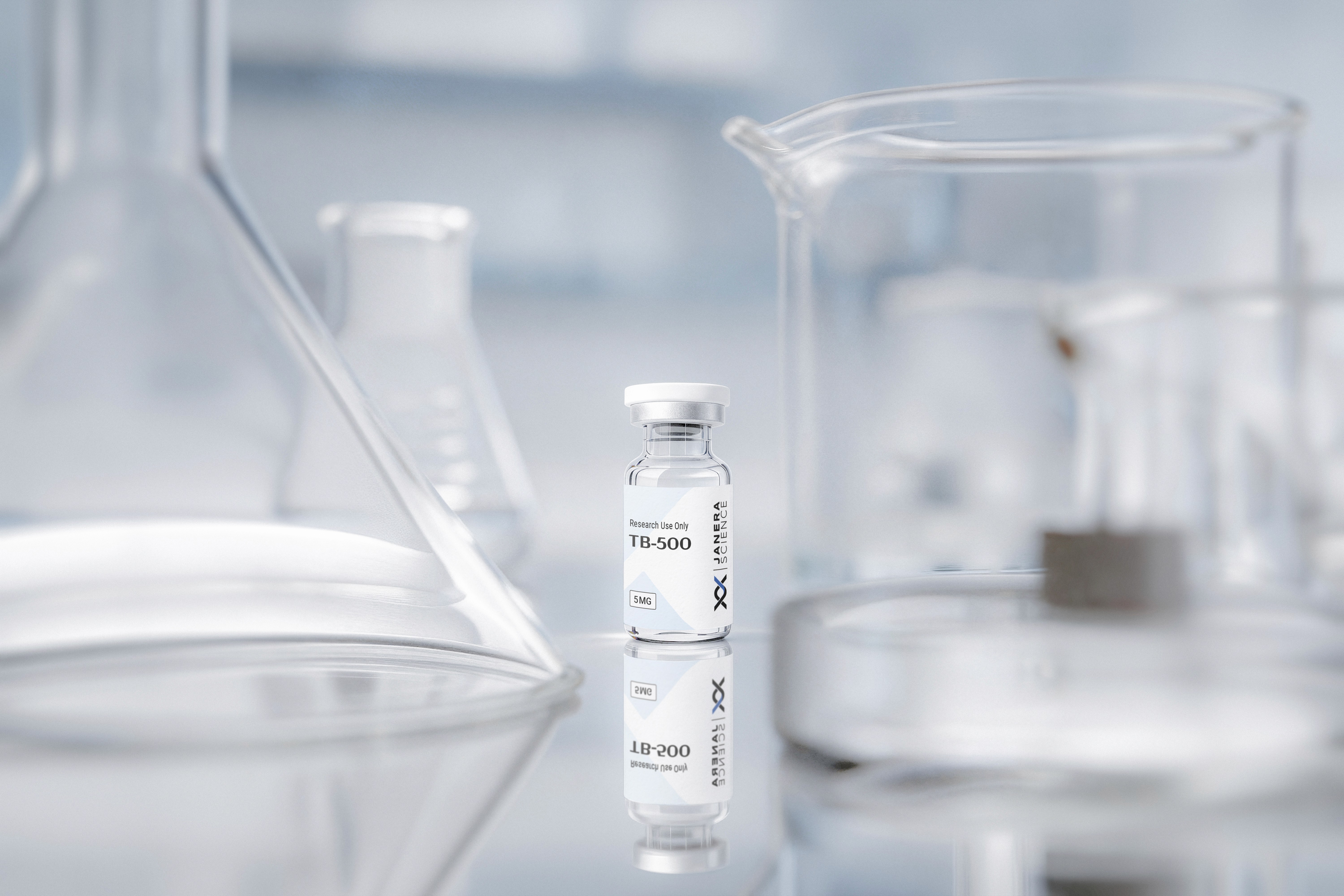 Janera Science TB-500 5mg research peptide vial standing on a reflective glass surface between a borosilicate Erlenmeyer flask and a glass beaker in a clean white laboratory setting, with vial label and reflection visible.