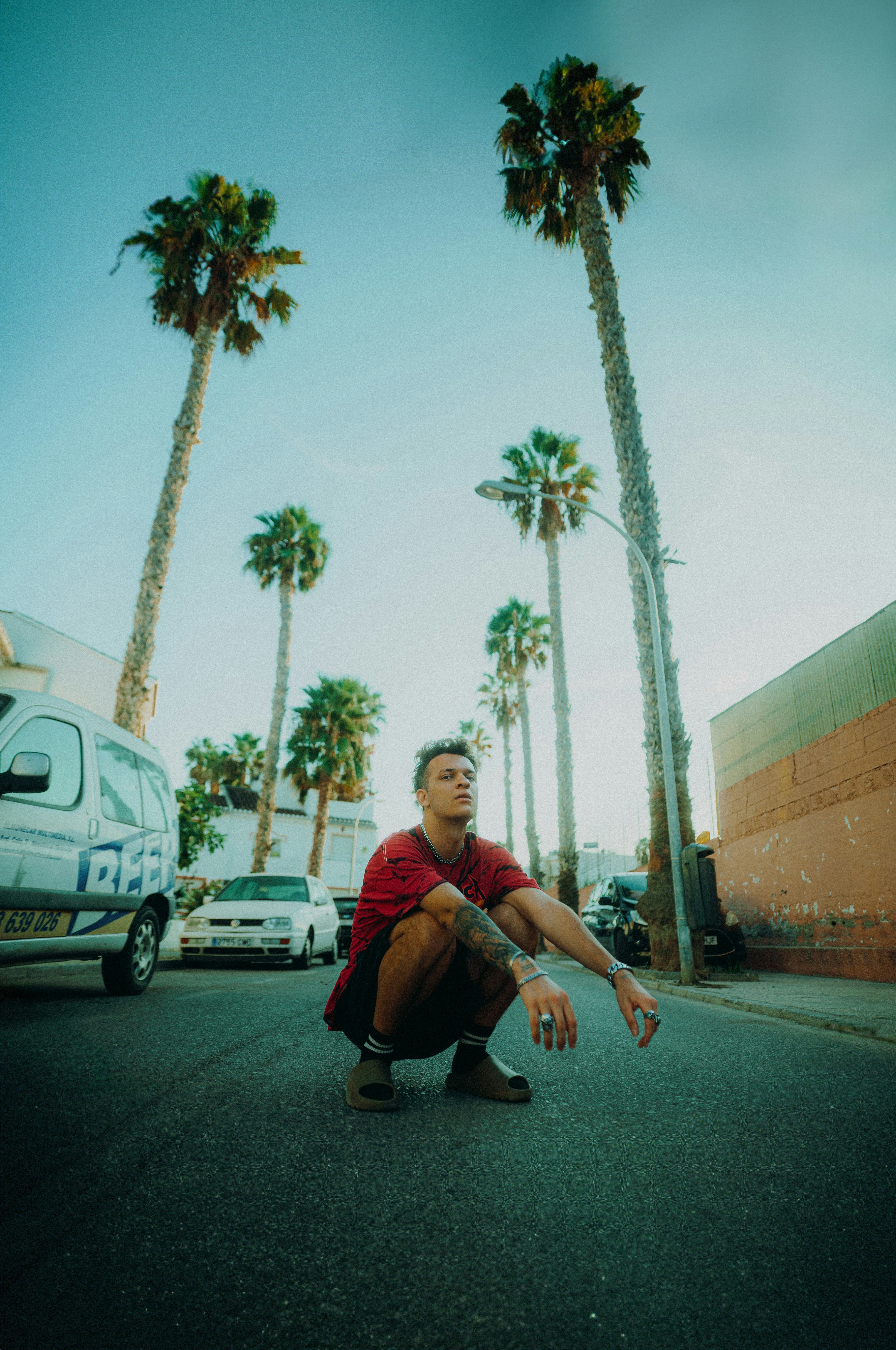 a man squatting down in the middle of a street