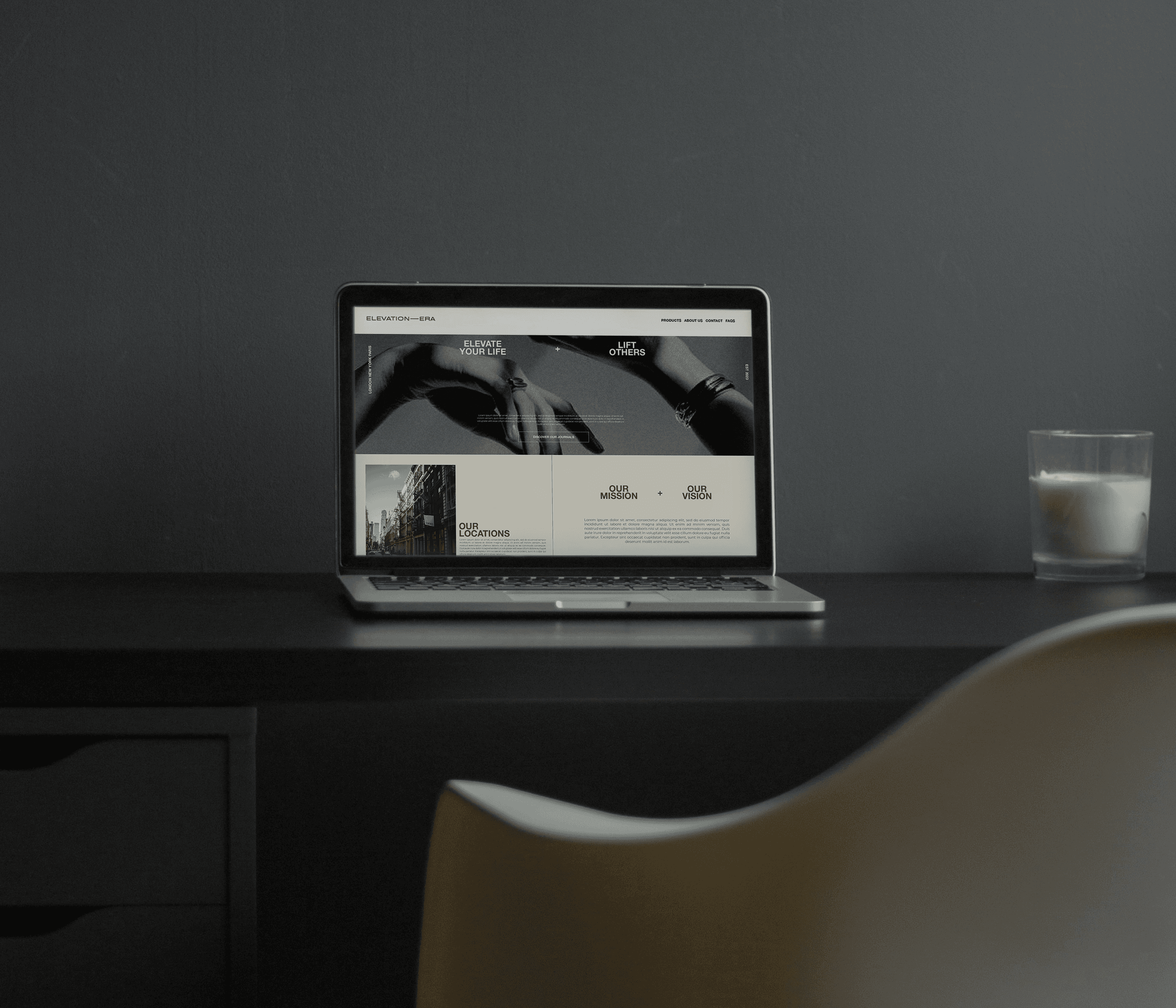 Mockup featuring an open laptop on a dark brown chair, with a grey curtain in the background. The laptop shows a web design for the lifestyle brand Elevation Era.