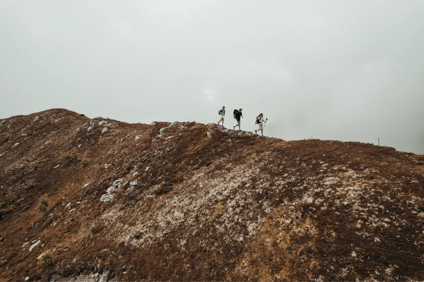 Trois personnes marchant sur un chemin de montagne