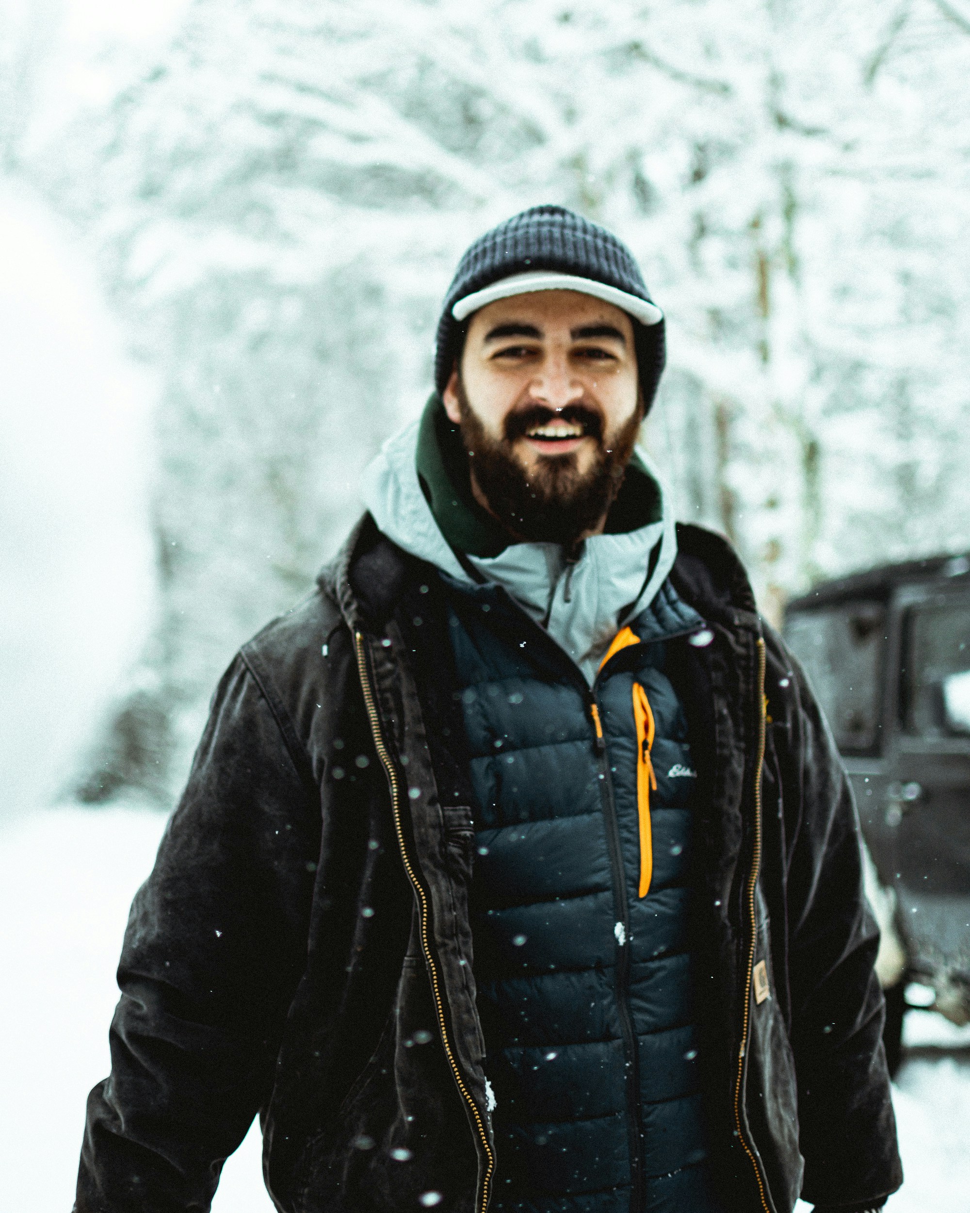 A man standing in front of a truck in the snow