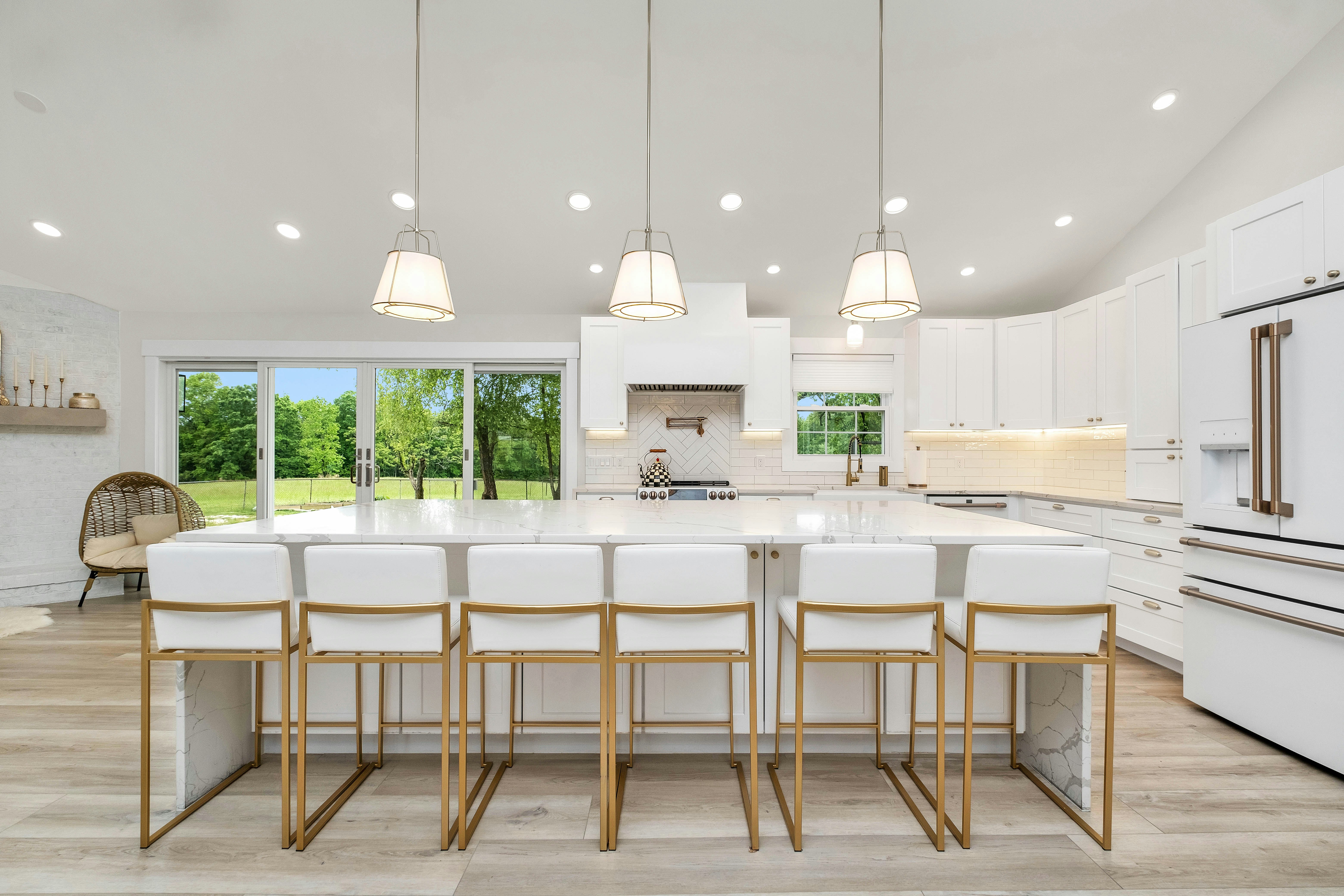 a large kitchen with a center island and white cabinets
