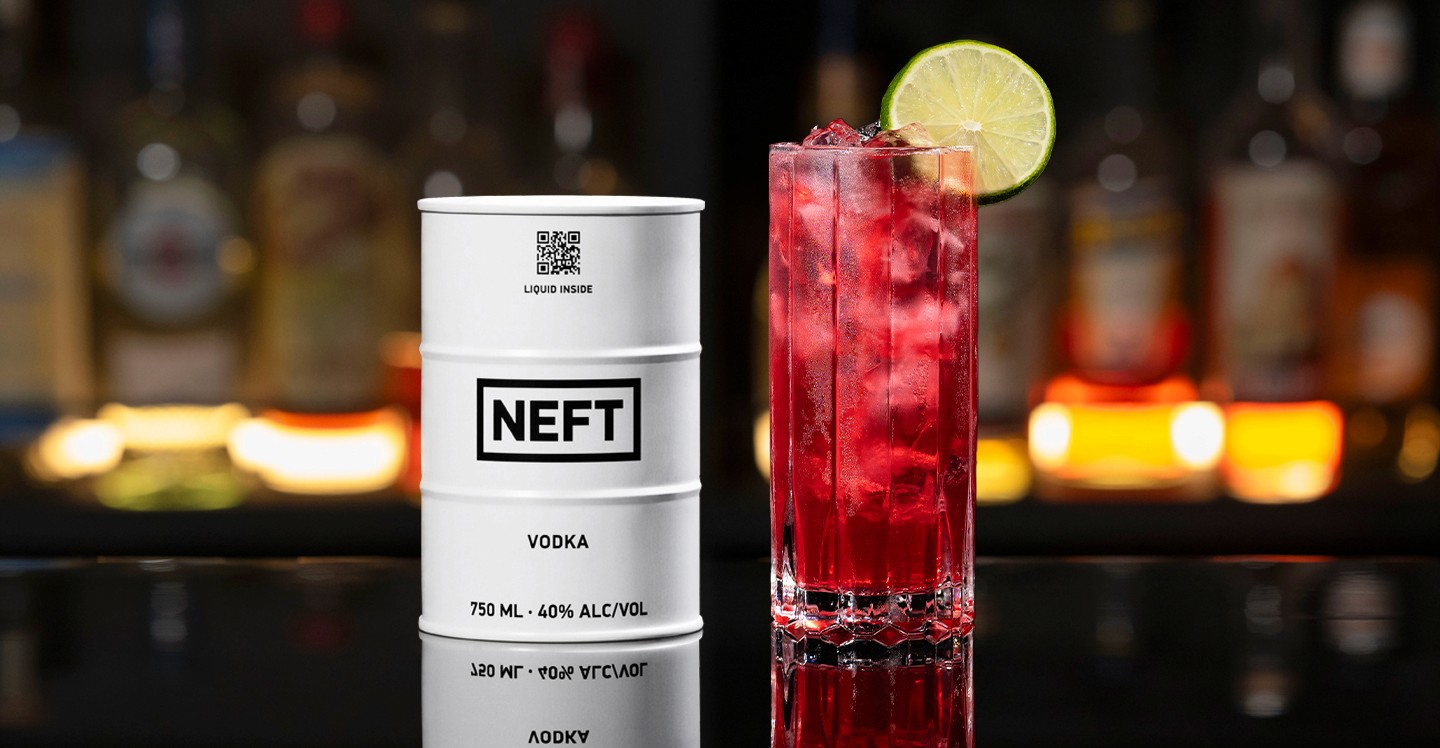 A NEFT Barrel and a glass of Sea Breeze on a bar counter.
