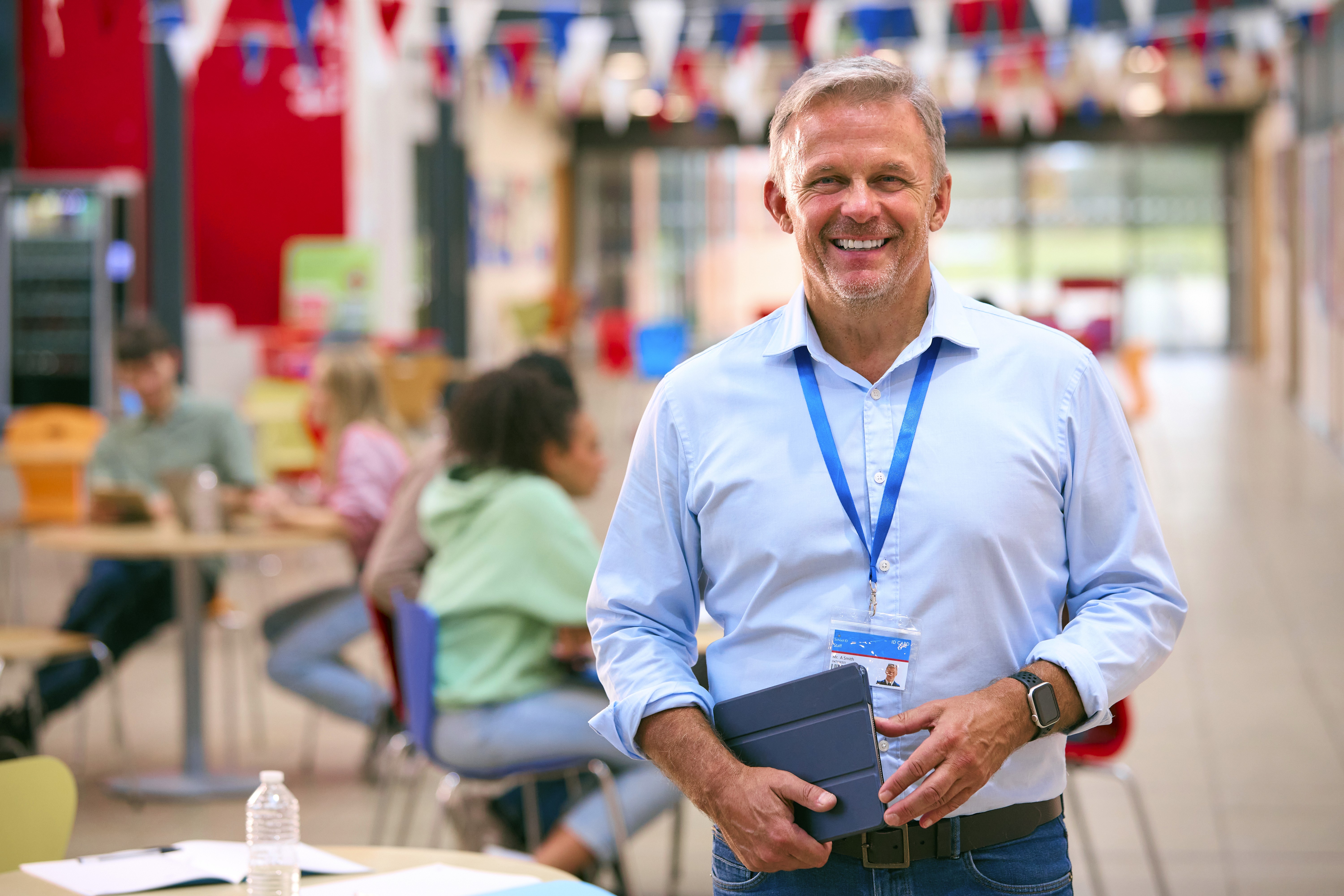 An image of a man who is a school teacher, smiling. He is smiling because of the post-crisis tools provided by Impact Suite and Emergent 3.