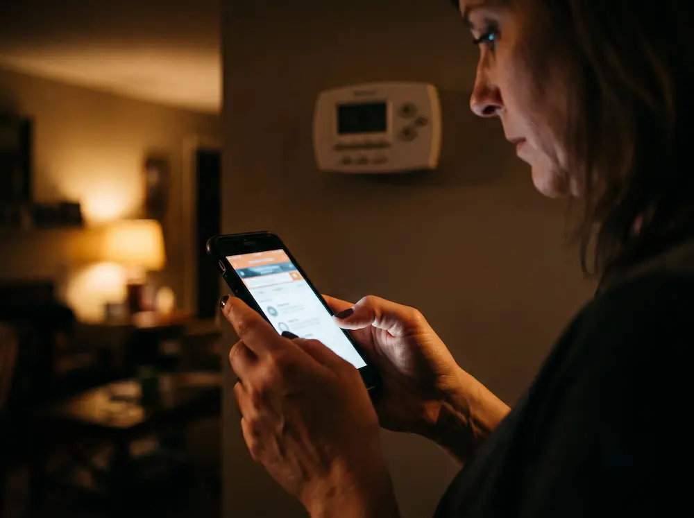 A homeowner searching for emergency AC repair on a phone late at night.