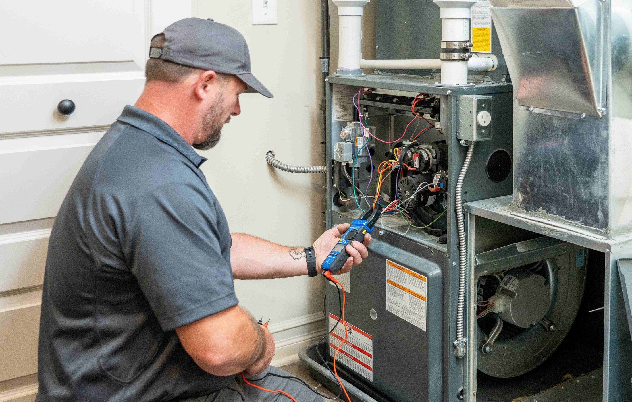 Technician testing furnace electrical components and checking for repair issues.