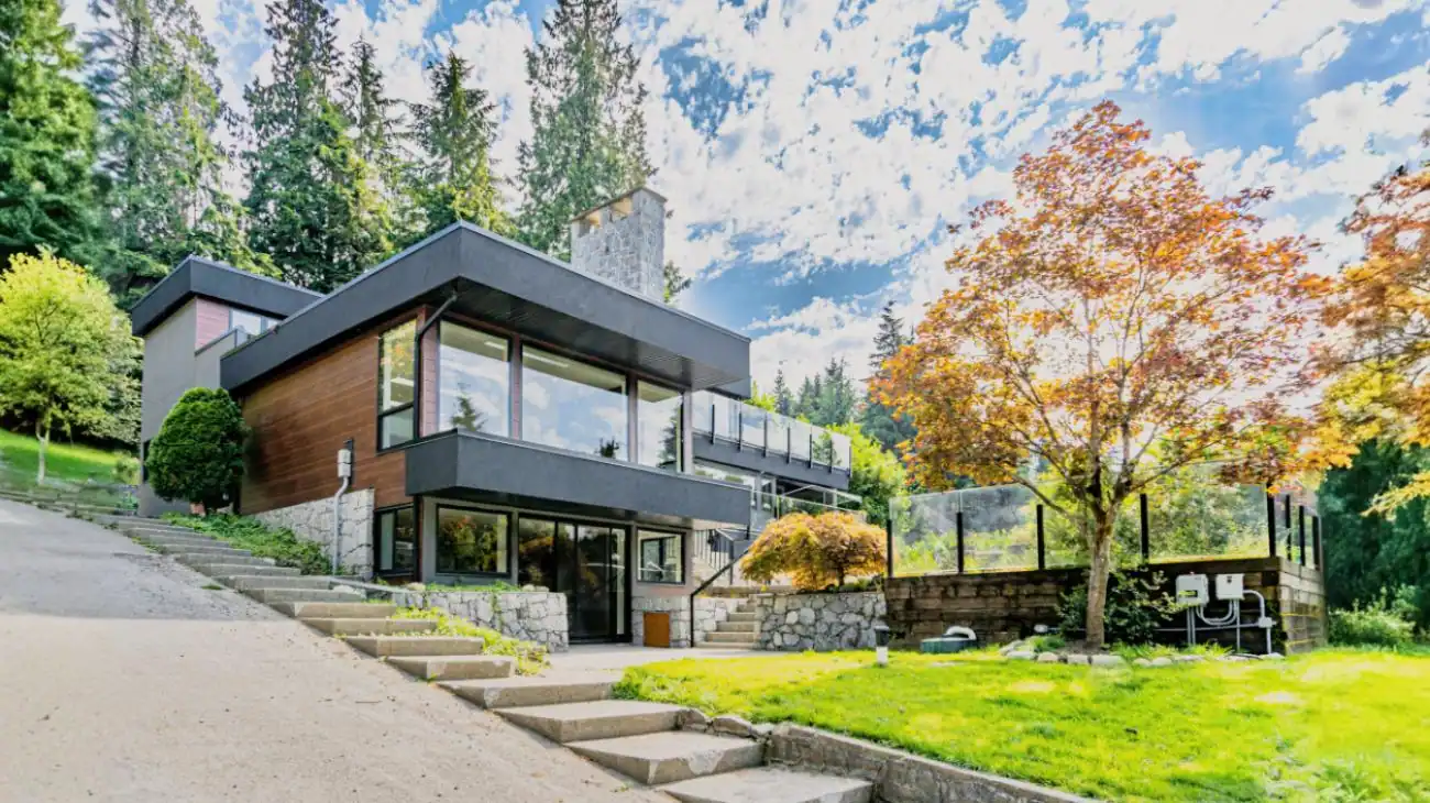 Modern custom home exterior in Vancouver featuring contemporary architecture with natural wood accents, stone retaining walls, and glass railings