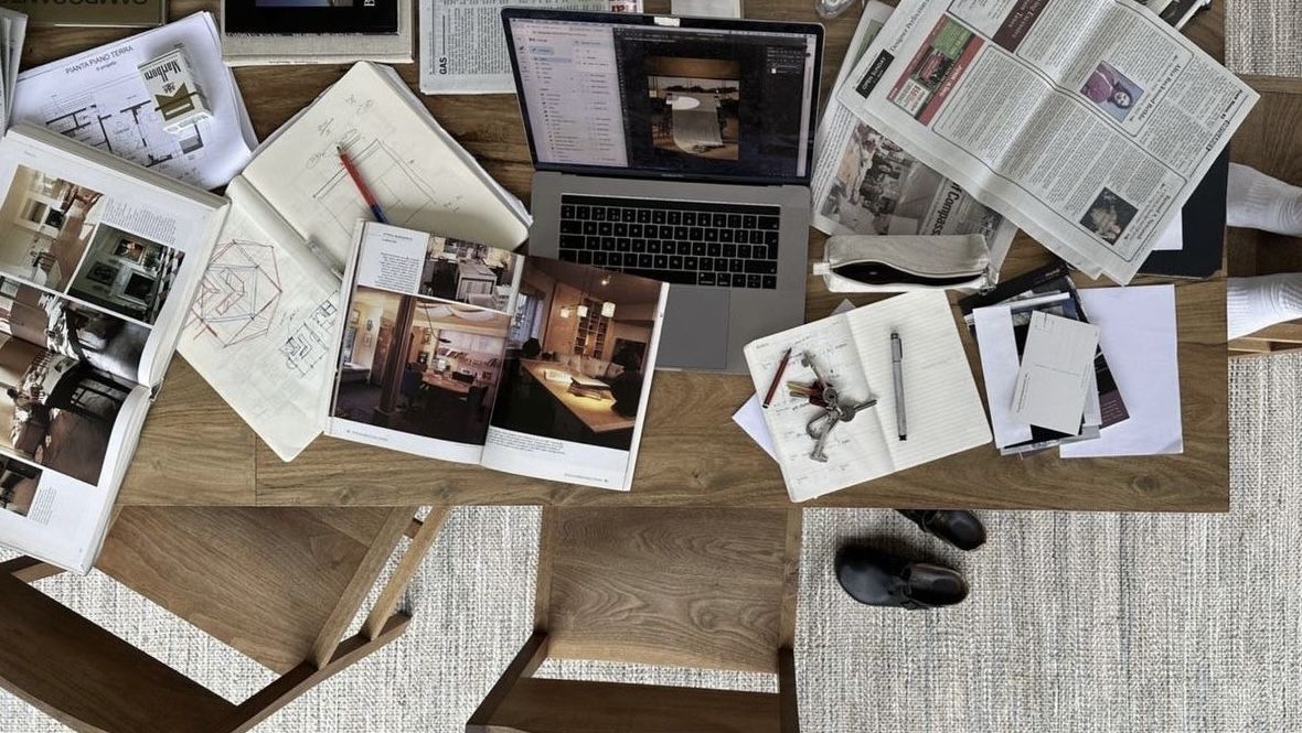 Una disposición plana de varias fotografías y documentos esparcidos sobre la superficie de una mesa de madera.