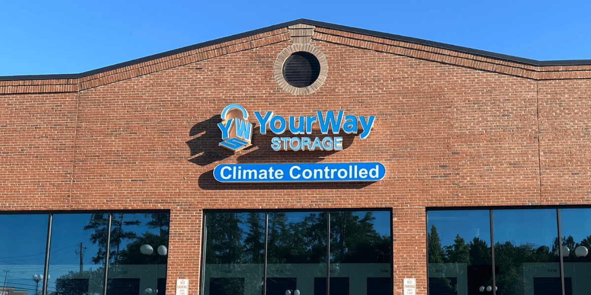 Exterior of YourWay Storage building with a sign displaying 'YourWay Storage' and 'Climate Controlled' on a brick wall.