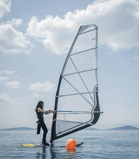 Femme s'entraine sur une planche à voile