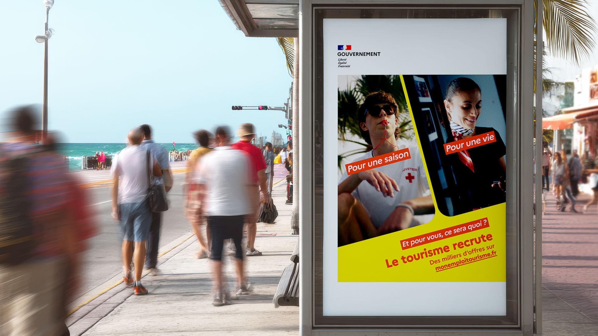 Affiche publicitaire du gouvernement français pour le recrutement dans le secteur du tourisme, placée dans un abribus en bord de mer. L'affiche clame "Le tourisme recrute" et montre des photos de métiers du secteur.