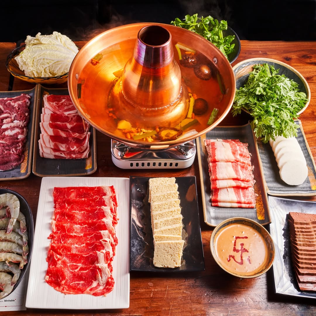 Mongolian hot pot stir fry served at Le Sia, featuring homemade sesame dipping sauce and fresh vegetables.