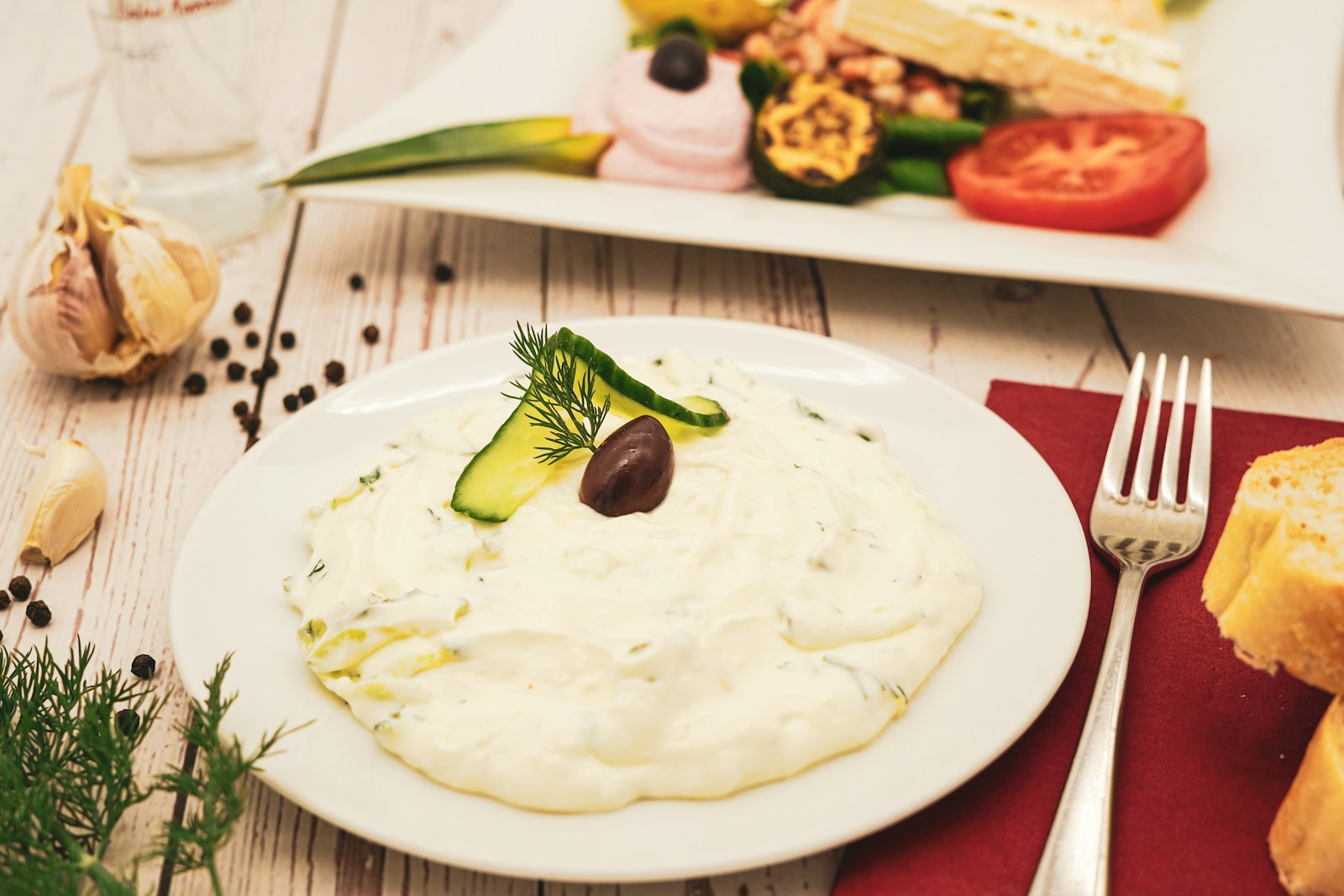 A plate of creamy Greek yogurt dip with cucumber and herbs, a simple high-protein food to help protect muscle and support healing
