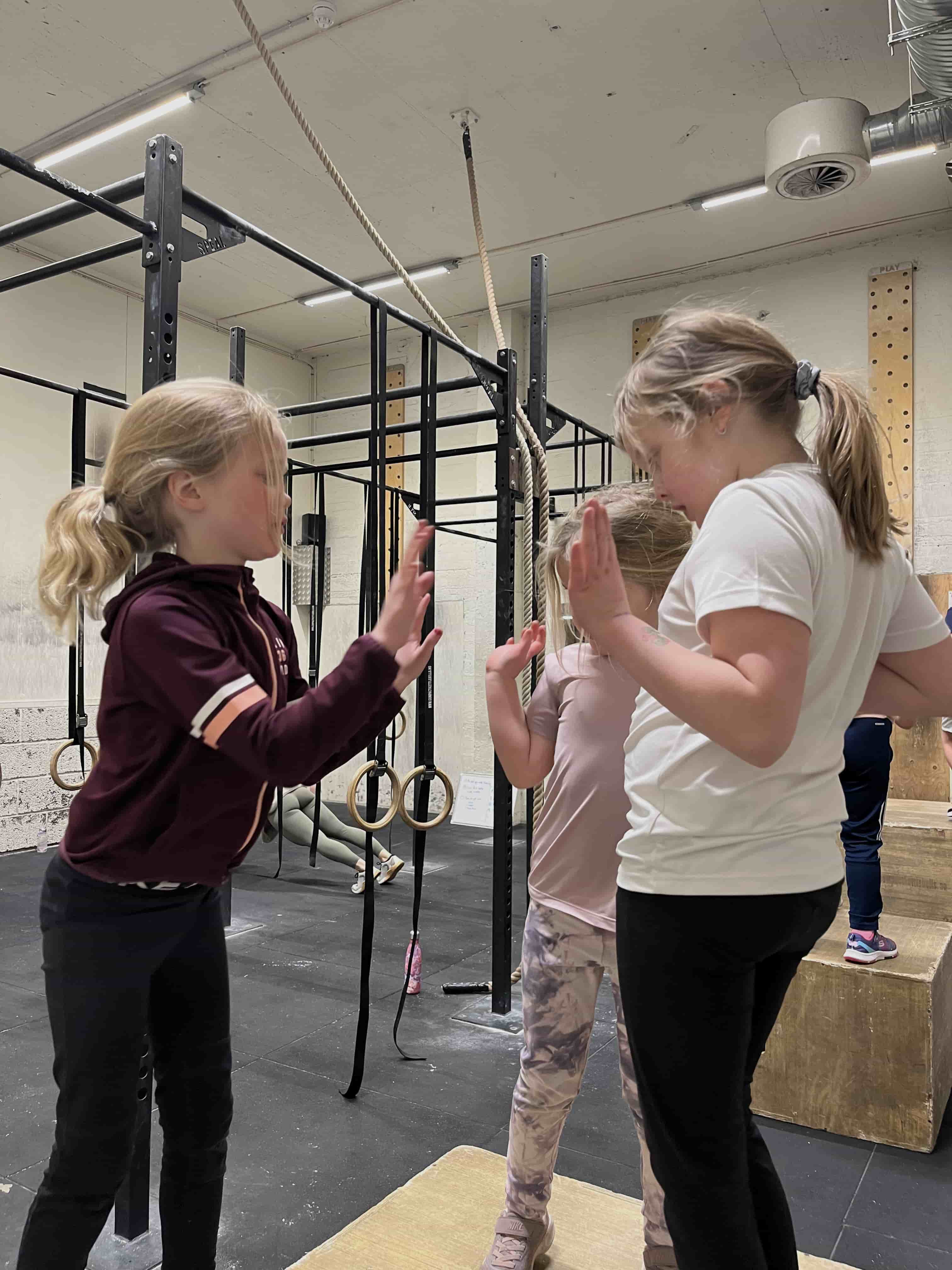 Barna har en lagøkt og gir high five til hverandre