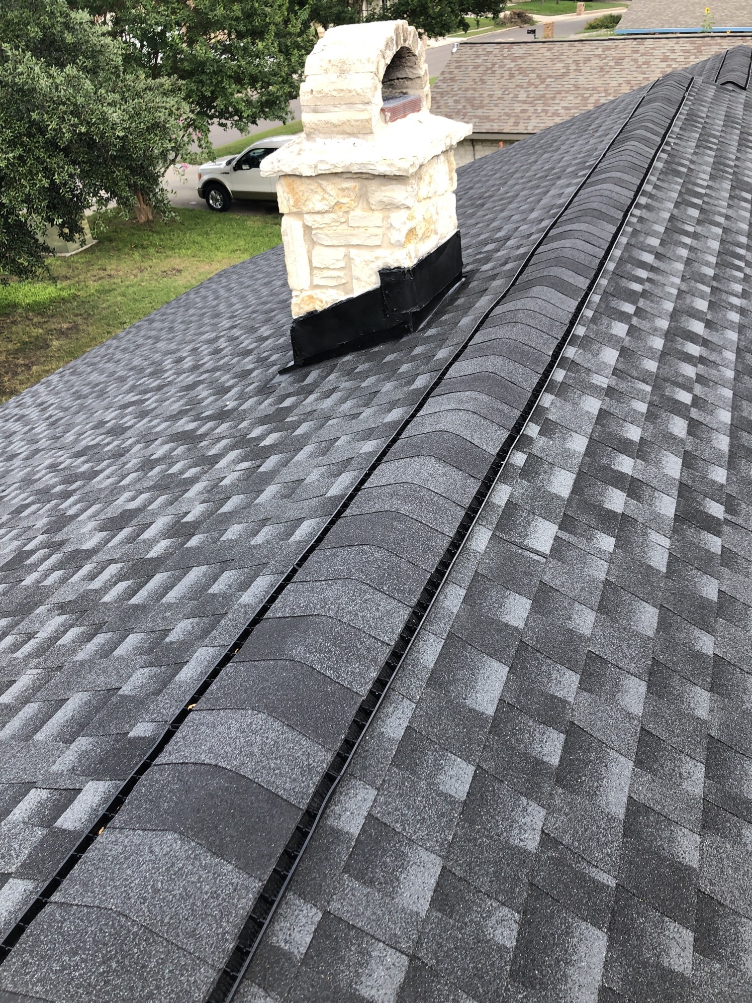 Stone chimney and surrounding roof details on a Barnes N’ Roofs project. Flashing deserves its own inspection.