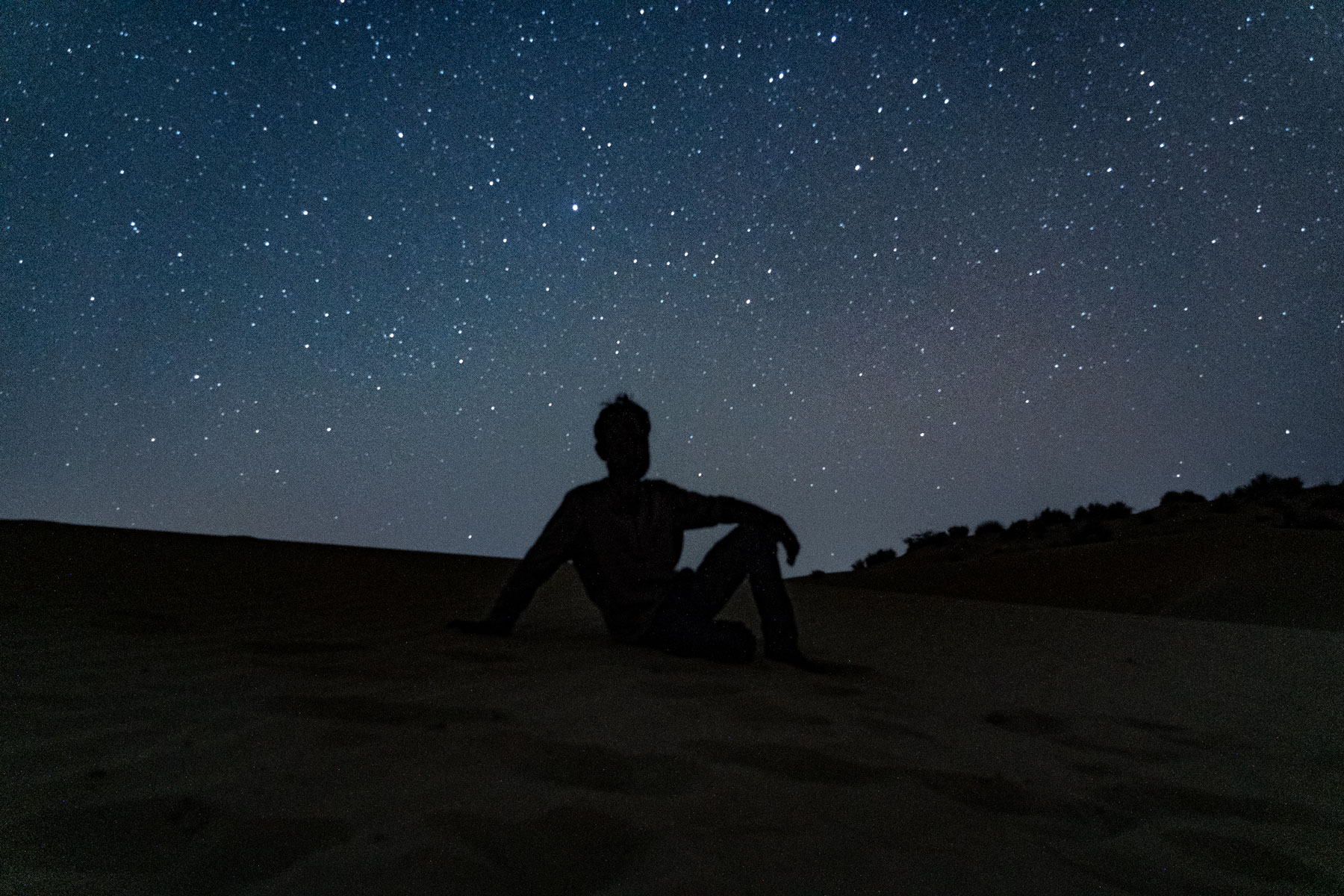 The camelguy in the middle of the Rajasthan desert during the night with stars 