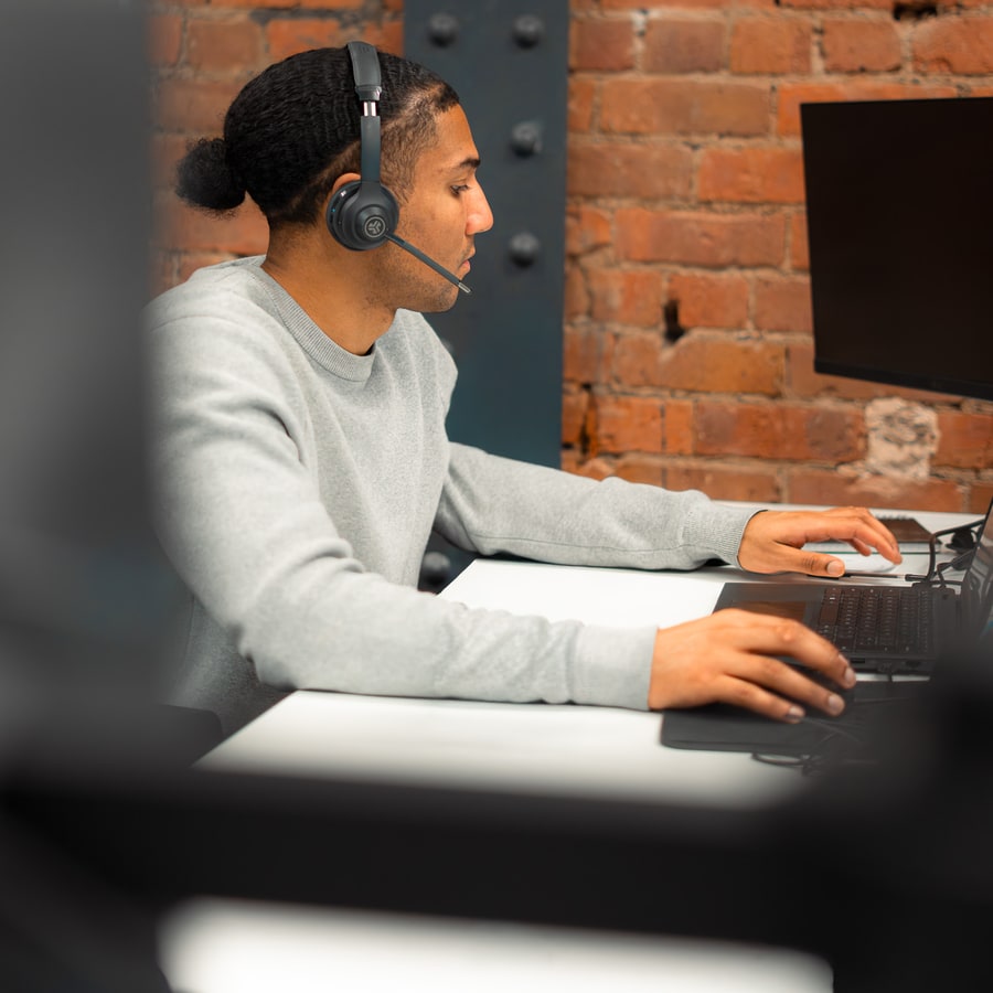 A PSS Tax adviser on a headset working through a technical claim at their desk
