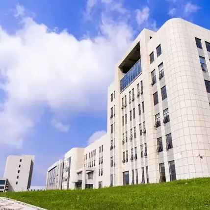 Modern, light-colored corporate buildings with numerous windows under a bright blue sky, symbolizing Jinyi Food's.