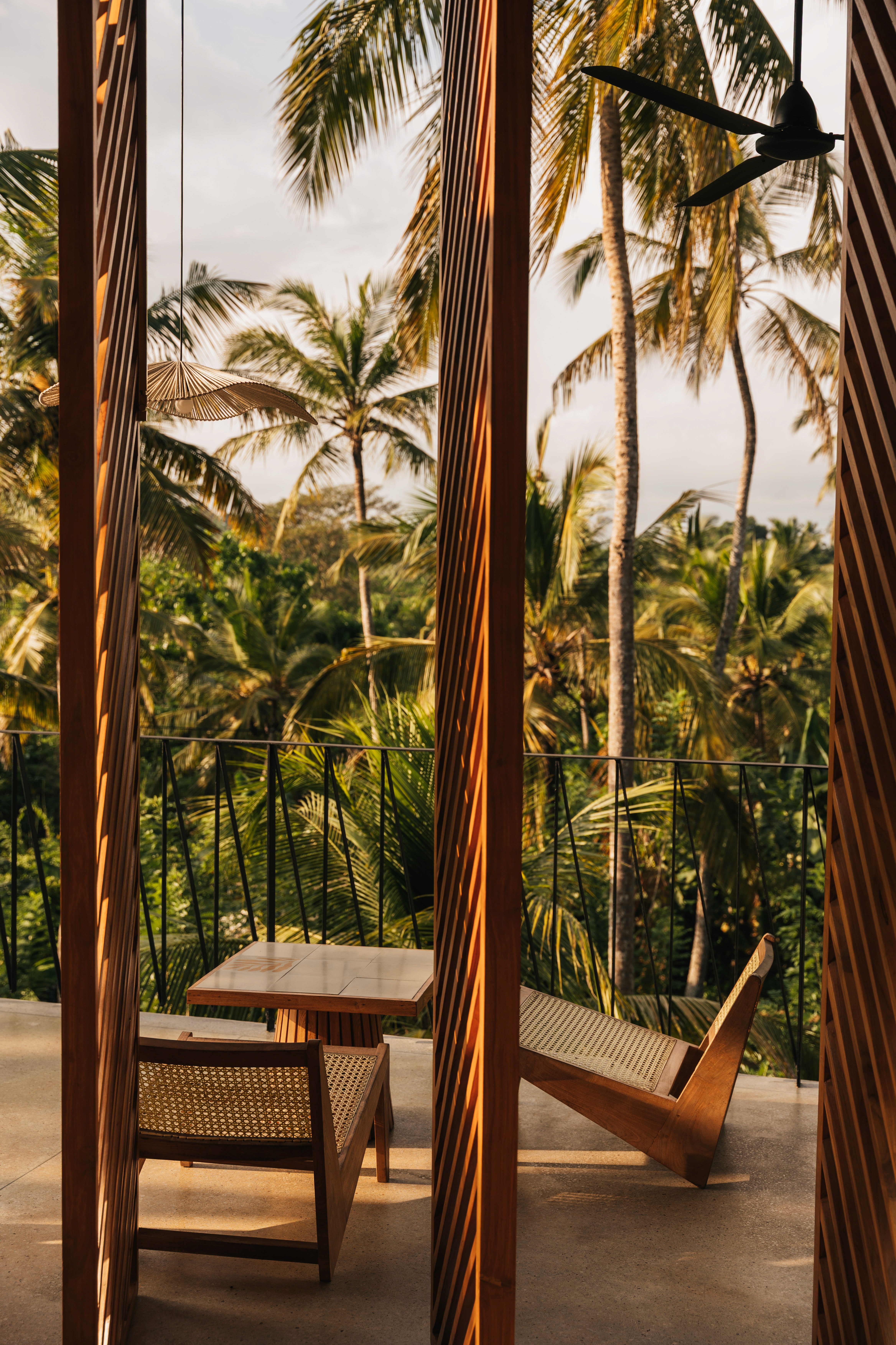 Restaurant of a boutique hotel surrounded by palmtrees at golden hour