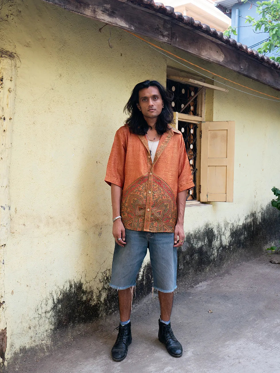 RAGA VII is a one-of-a-kind half-sleeve shirt, crafted from vintage fabric in a bold orange print with a detailed button placket, classic collar, and unique back detail.