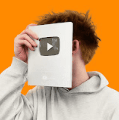 A woman with a red bow headband and bright orange and blue clothing poses against a teal and orange geometric background. Her expression is confident.