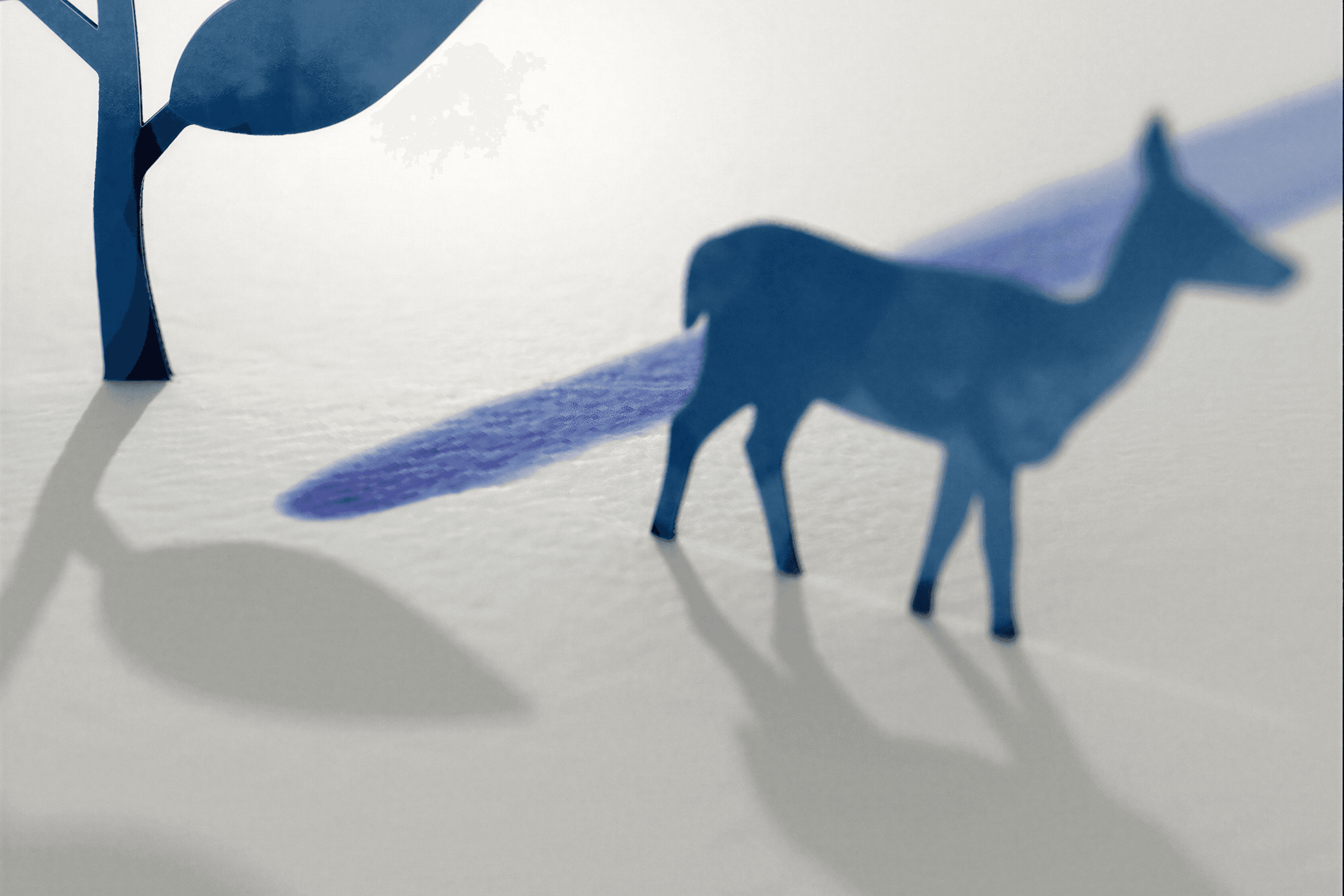 Paper cutout of a deer and tree with shadows