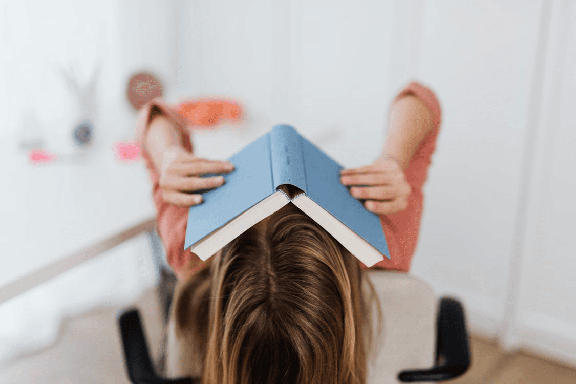 Woman Covering Her Face with a Book