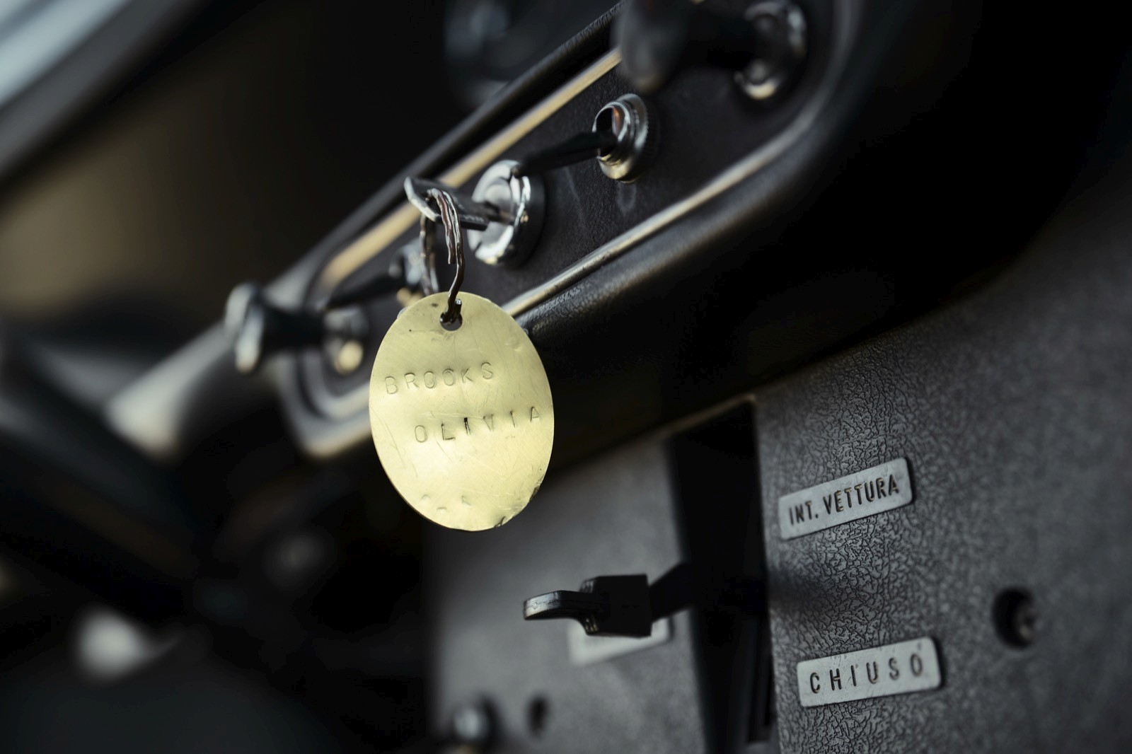 Close-up of a car's dashboard with a key and a yellow tag attached to the ignition area.