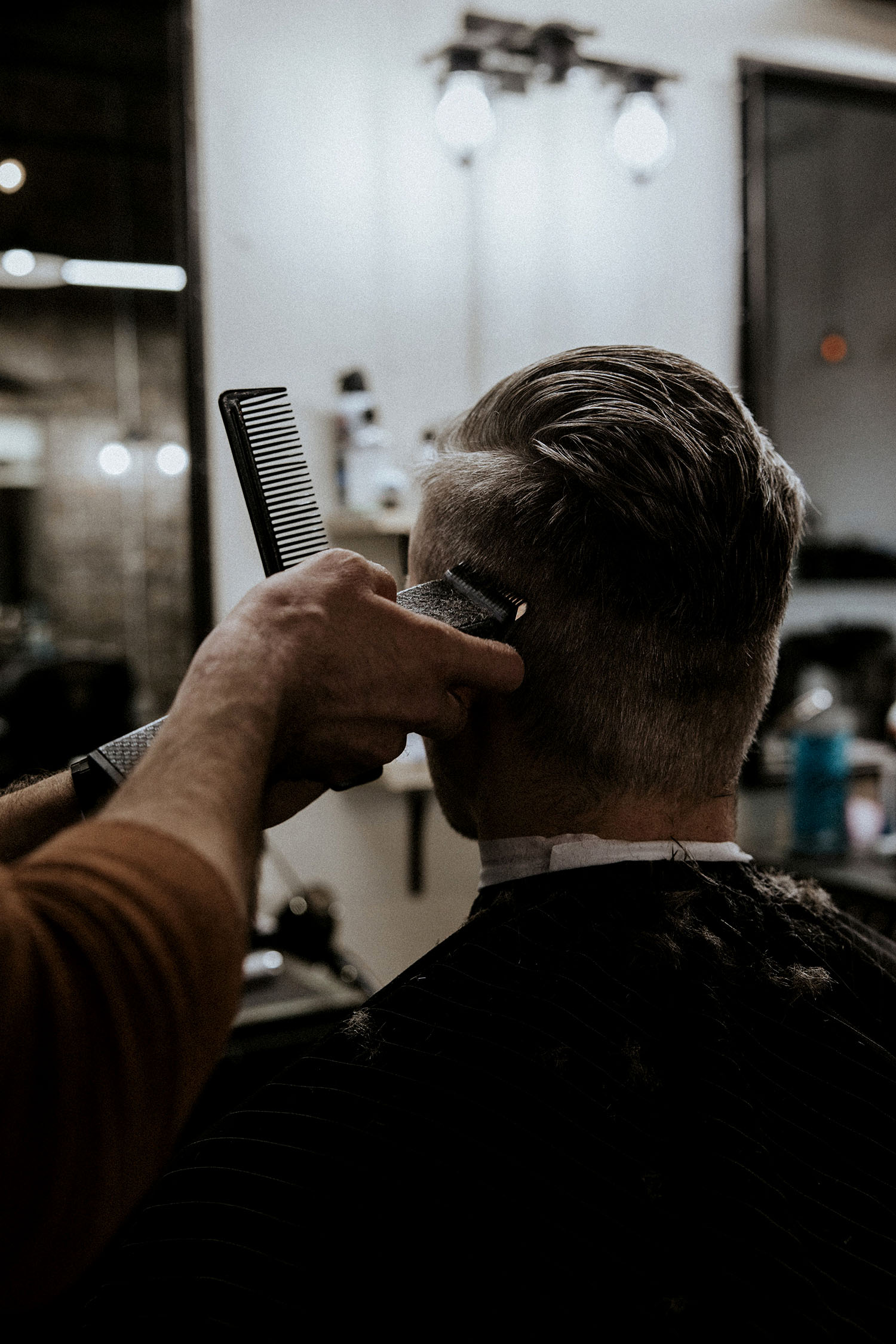 Close-up photo of a barber using clippers to refine a client’s haircut at Old Town Barber in Chicago, showcasing precision and craftsmanship in men’s styling.
