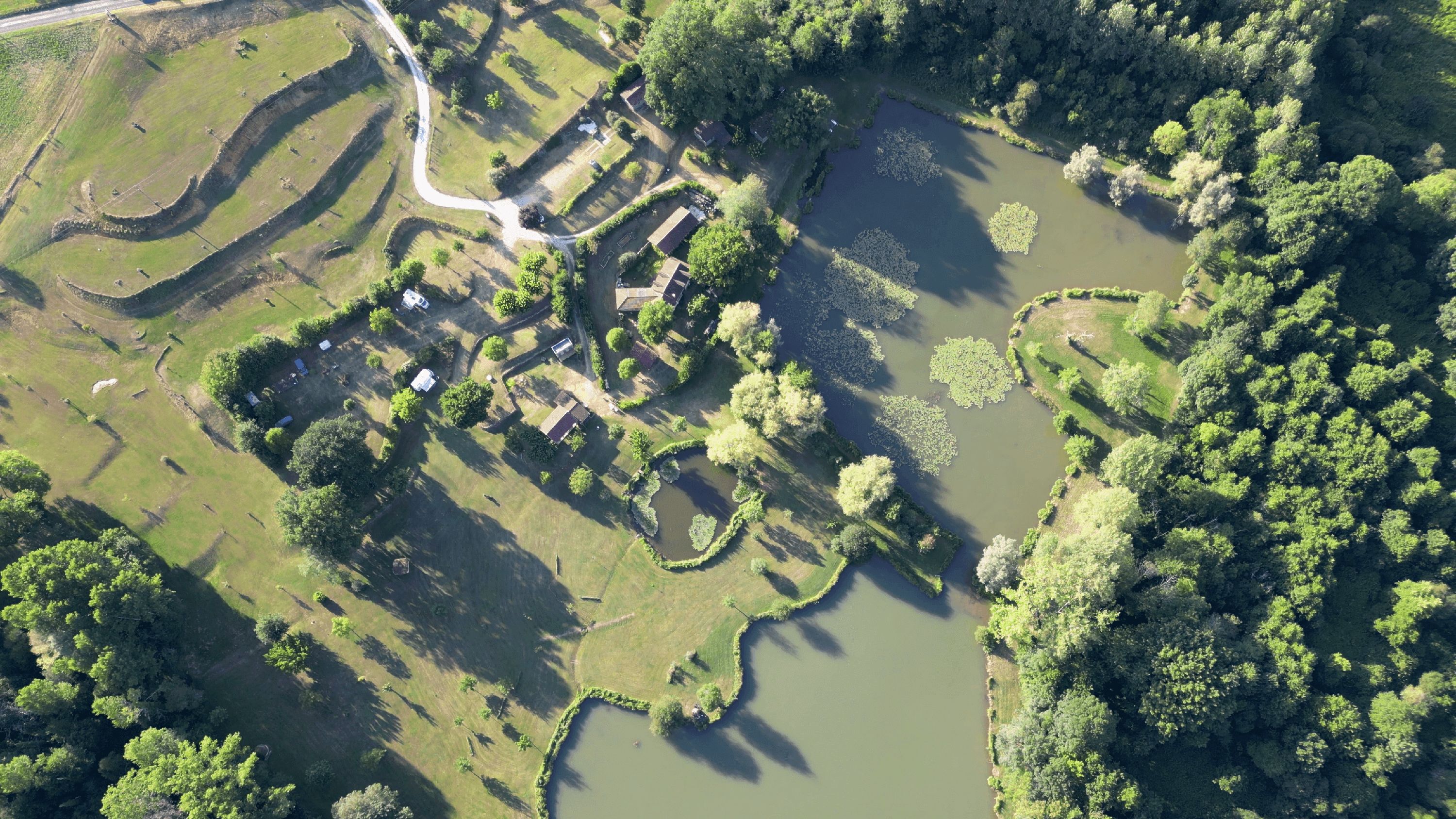 Photo aérienne du domaine de la brame montrant les étangs de pêche, le footgolf, les airs de camping car et la nature verdoyante