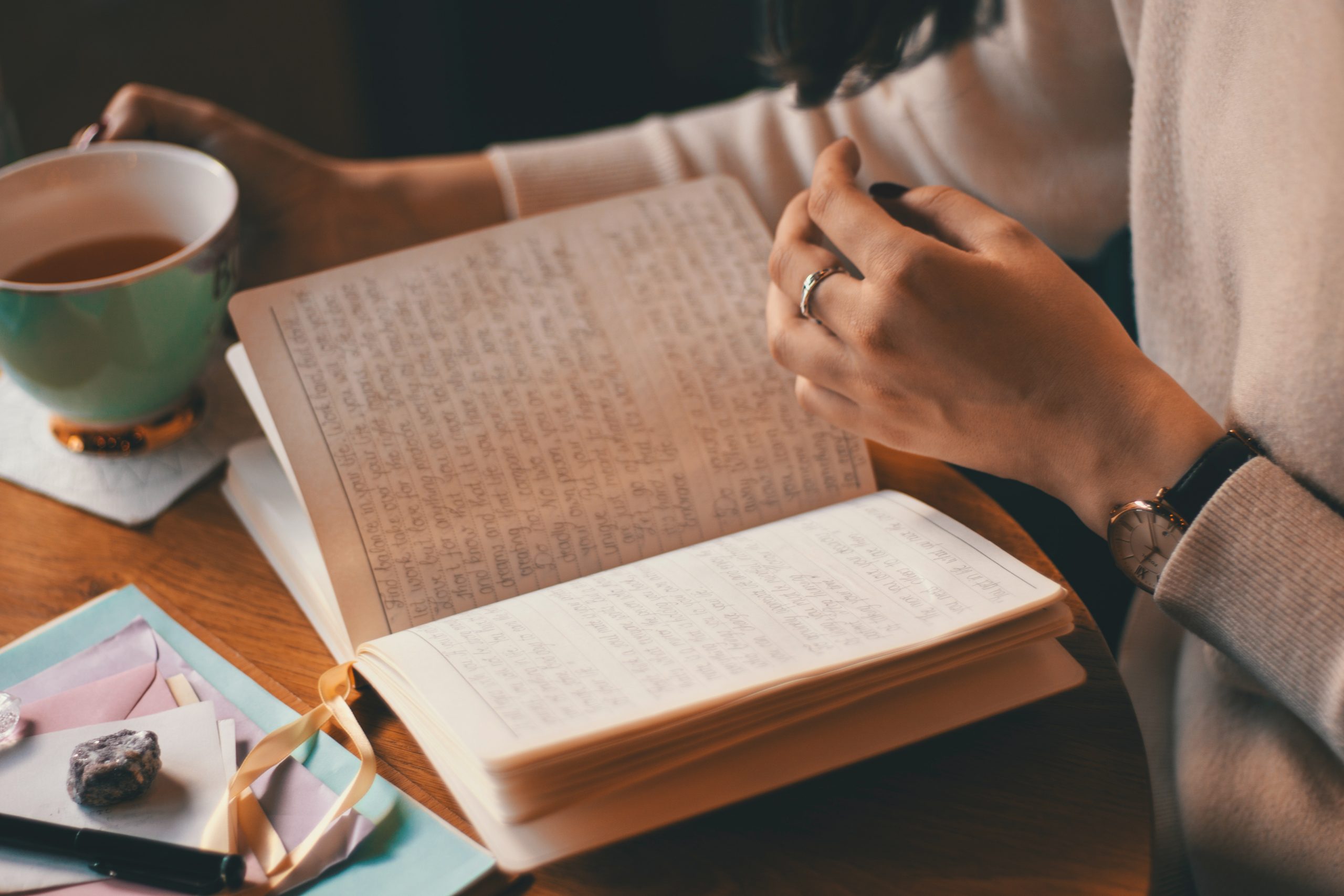 An image showing a journal book with a cup of tea