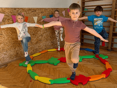 Děti trénující rovnováhu na překážkové dráze v tělocvičně