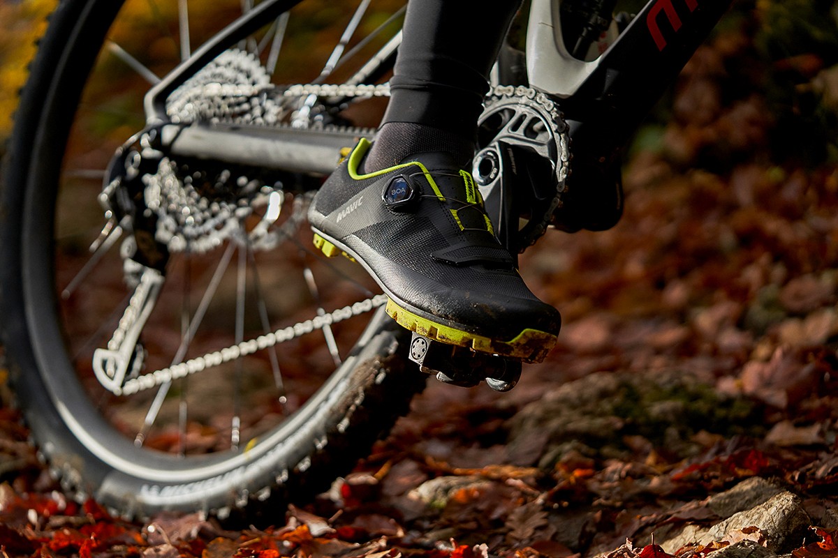 Photographie close-up chaussures et roue de vélo XC homme en forêt