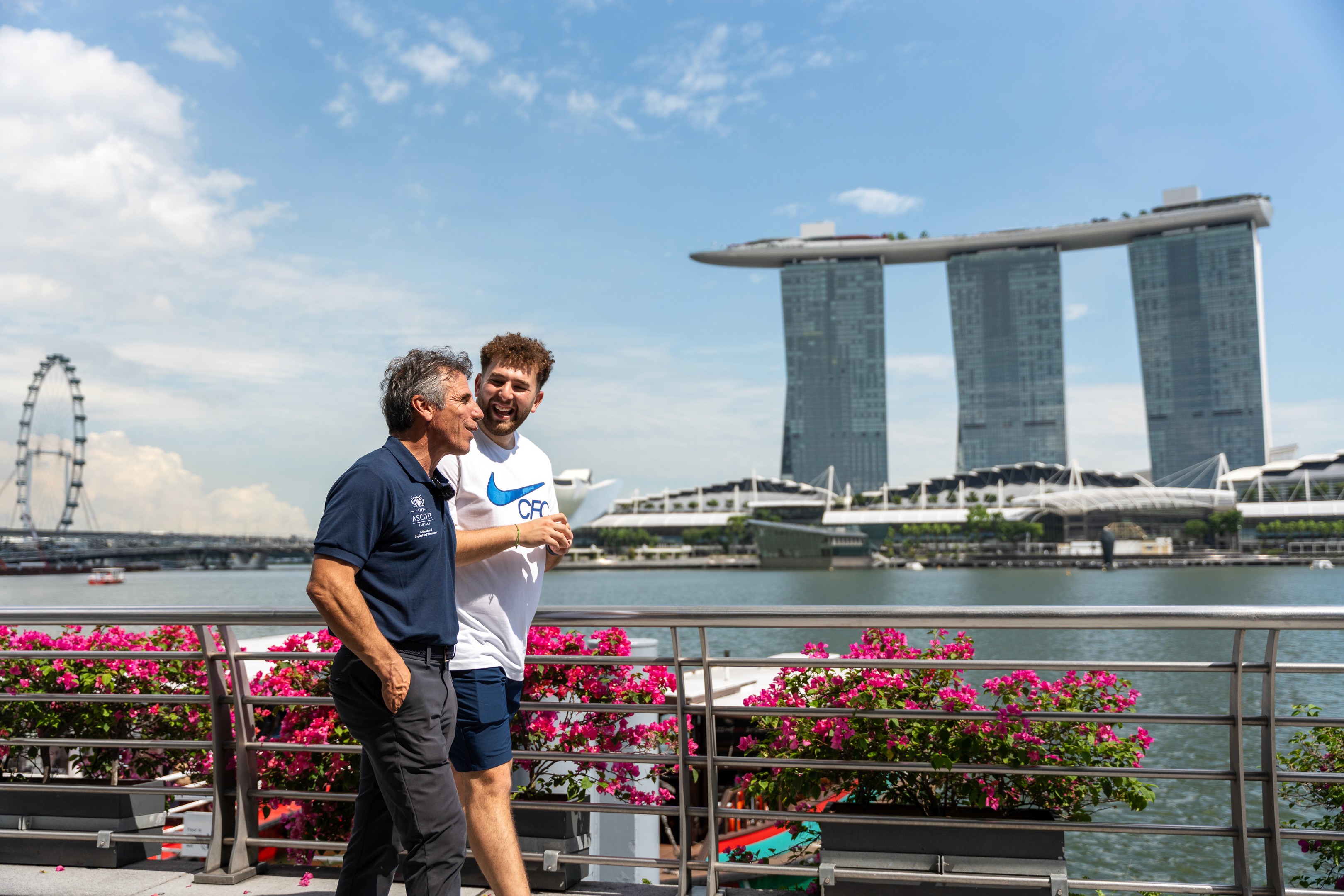 Gianfranco Zola walking with Zac Djellab Marina Bay Sands and the Singaore Flyer in the background, for The Famous CFC  in Singapore, 2024