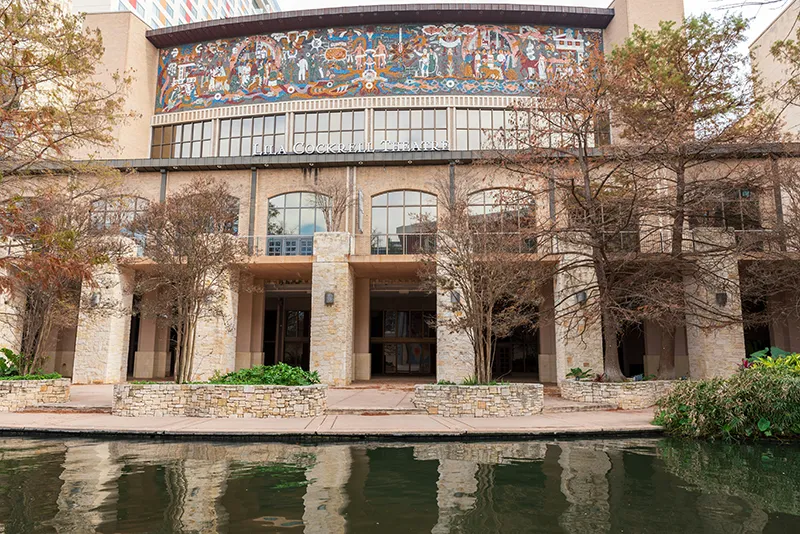 Lila Cockrell Theatre building along the San Antonio River Walk, featuring a large mosaic mural on its upper facade