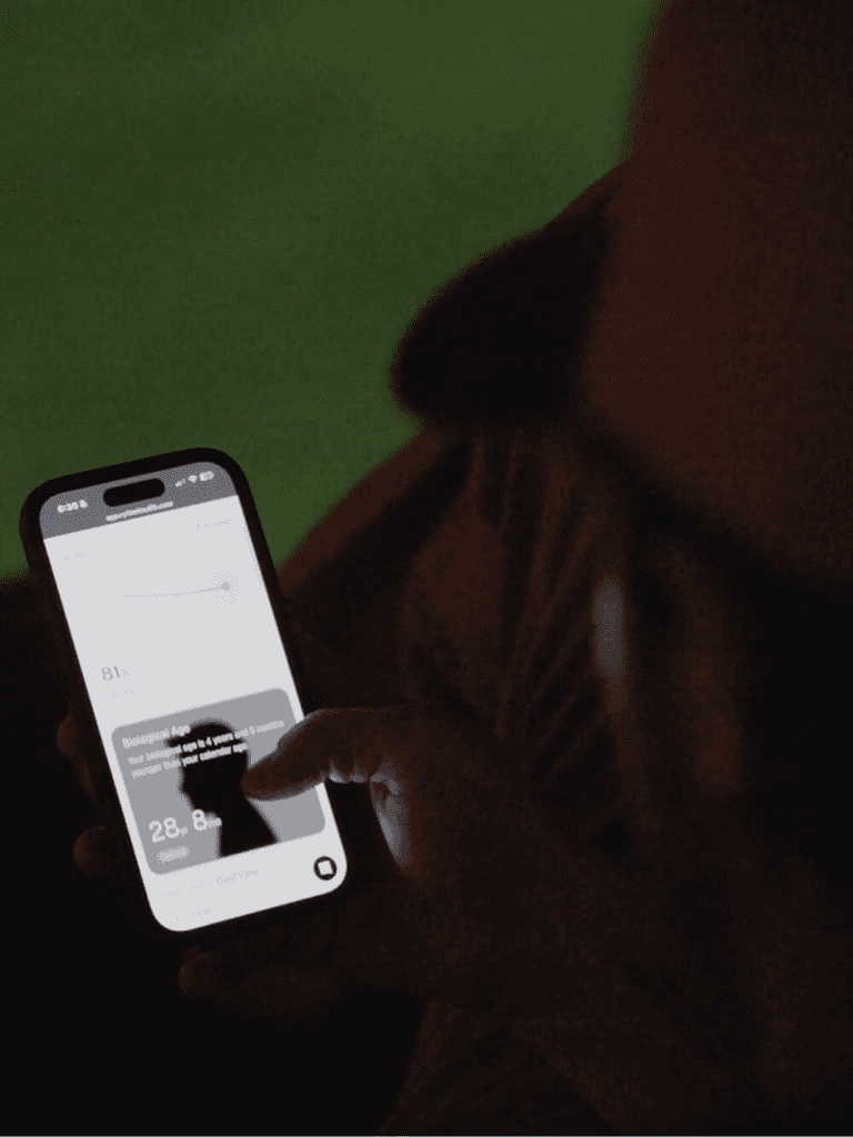 Person holding a smartphone displaying the Rythm Health app, showing a hormone score and health metrics on screen.