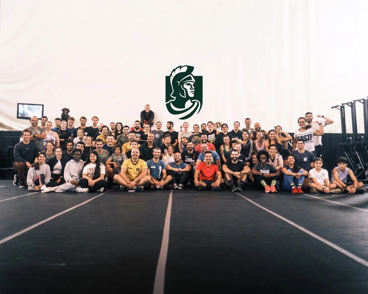 Foto de grupo de atletas de crossfit com uma marca ao fundo