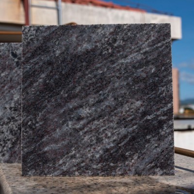 A square slab of dark grey granite, showcasing the natural veining and texture of the stone. This piece is often used in tombstone or memorial construction for its durability and visual appeal.