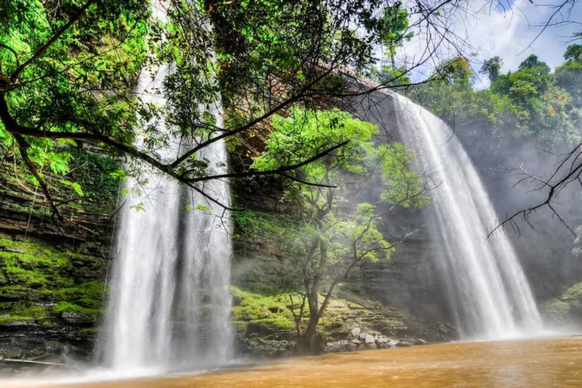 The powerful Boti Falls twin waterfalls cascade into a pool.