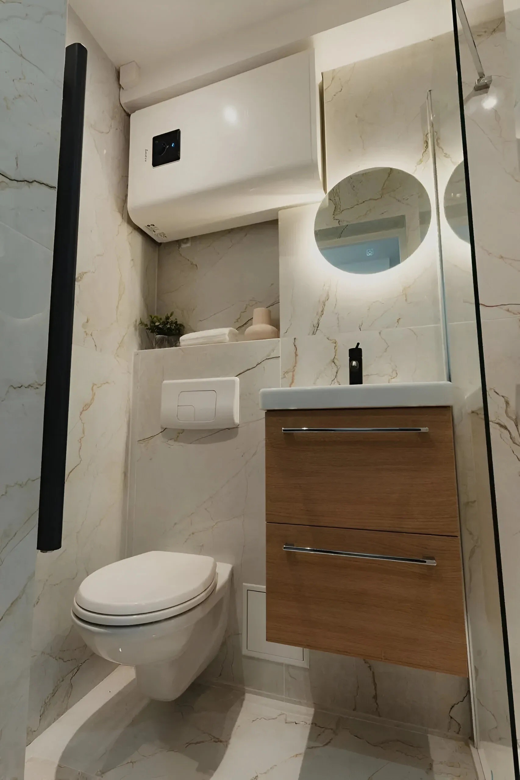 Optimisation d'une salle de bain exiguë avec WC suspendus, carrelage effet marbre et finitions soignées.