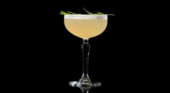 A closeup of a Nellie Bly drink against a dark background.