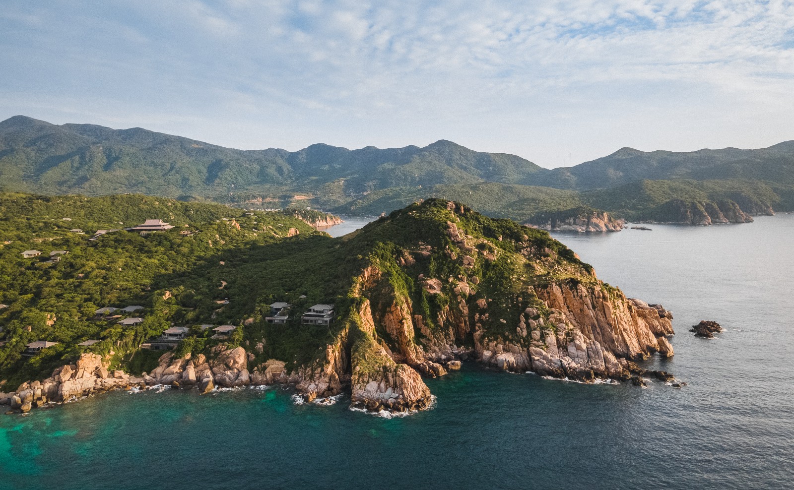 Amanoi's dramatic rocky headland rising from turquoise waters