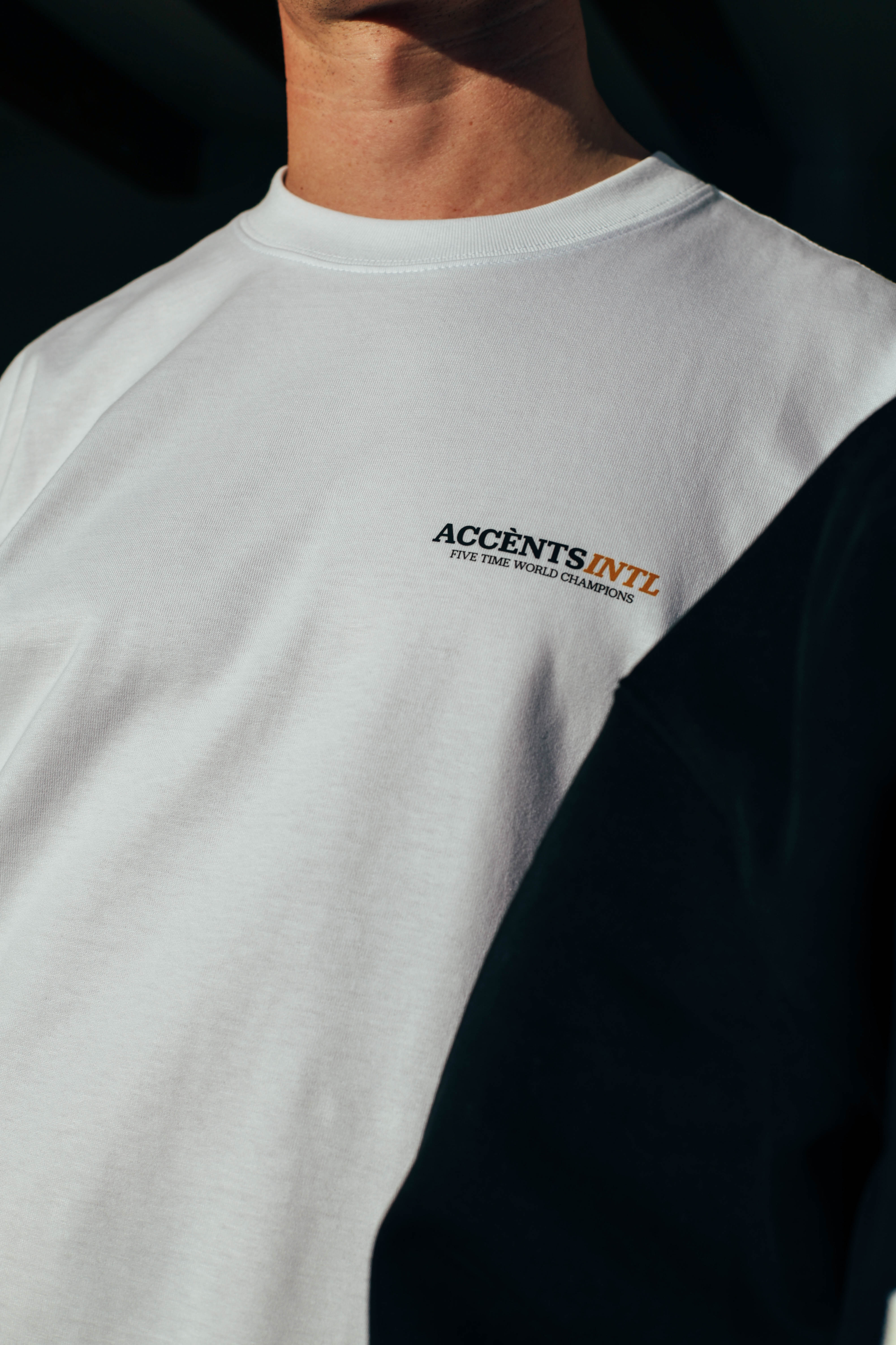 Man wearing white t shirt with retro design on black background