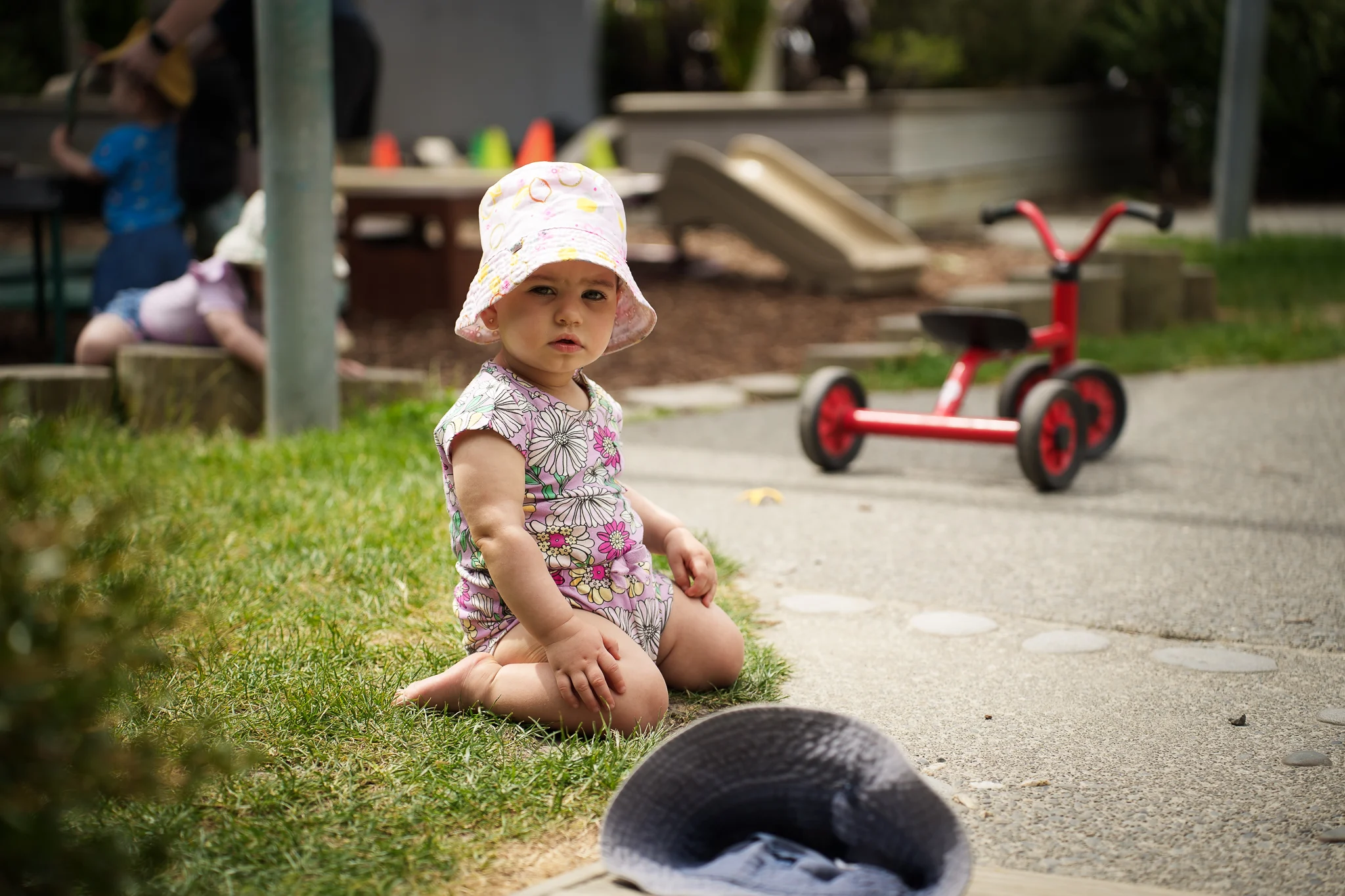Young children engage in supervised water play with a teacher in an outdoor early childhood environment.