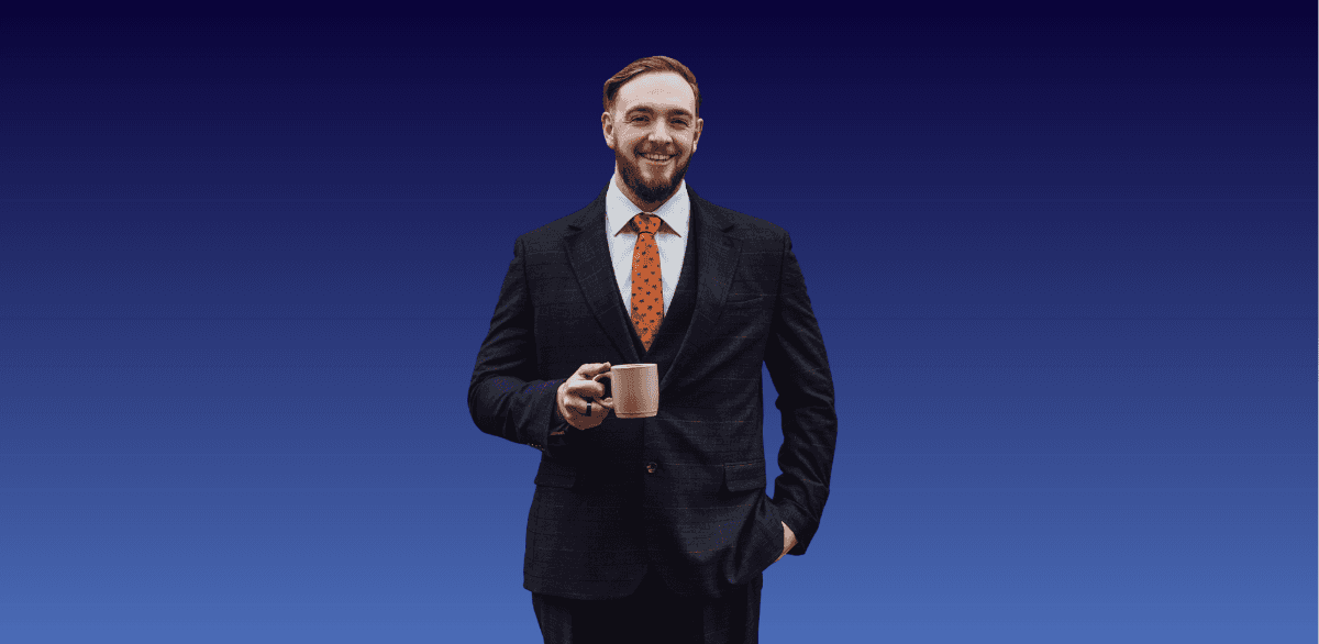 A man in a suit. He's smiling, has short hair and a beard